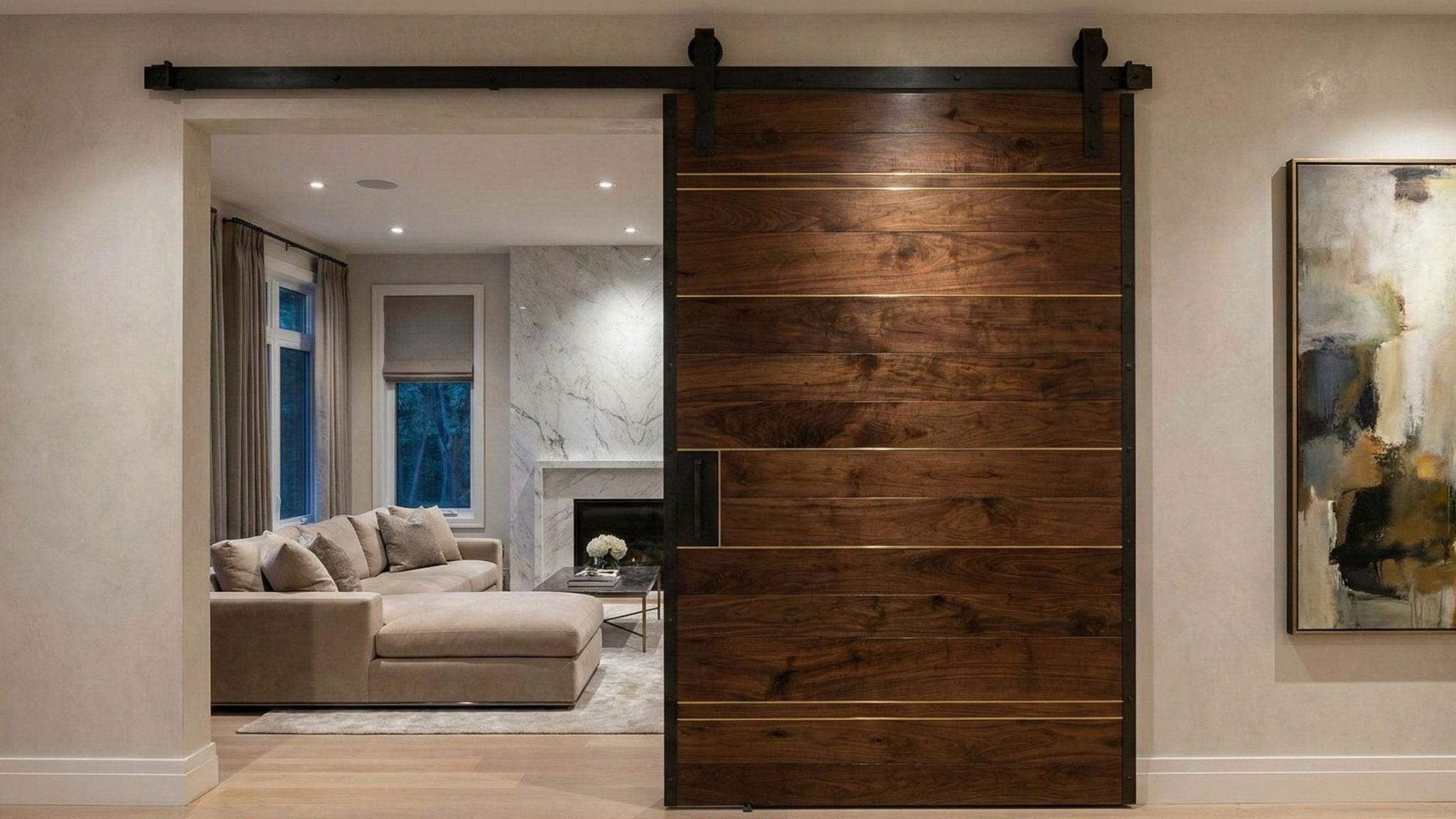 A sleek, modern sliding barn door made of dark, horizontally planked wood with thin gold metal inlays hangs on a black track system.