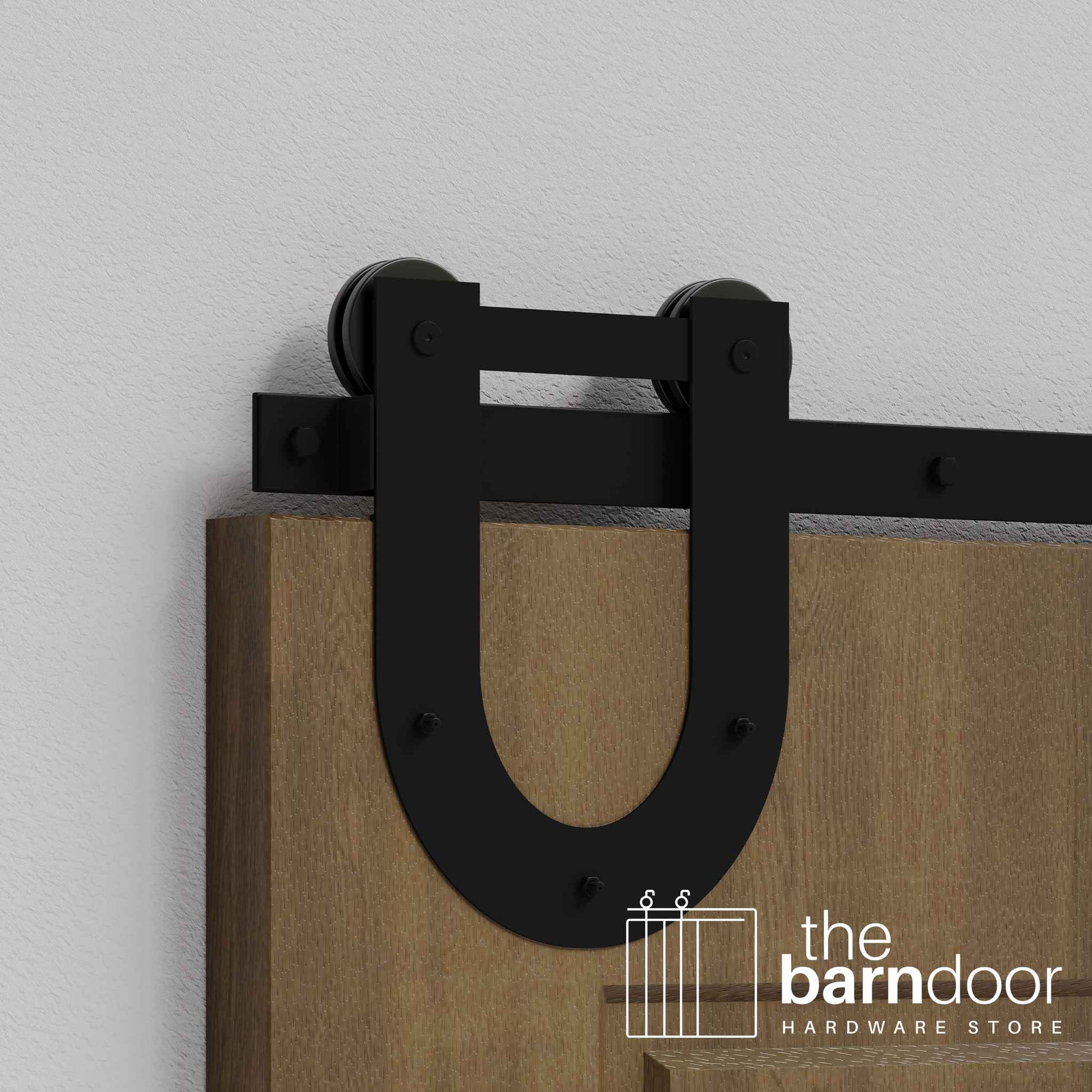 Close-up of Black Horseshoe Single Track barn door hardware installed on a wooden door panel.
