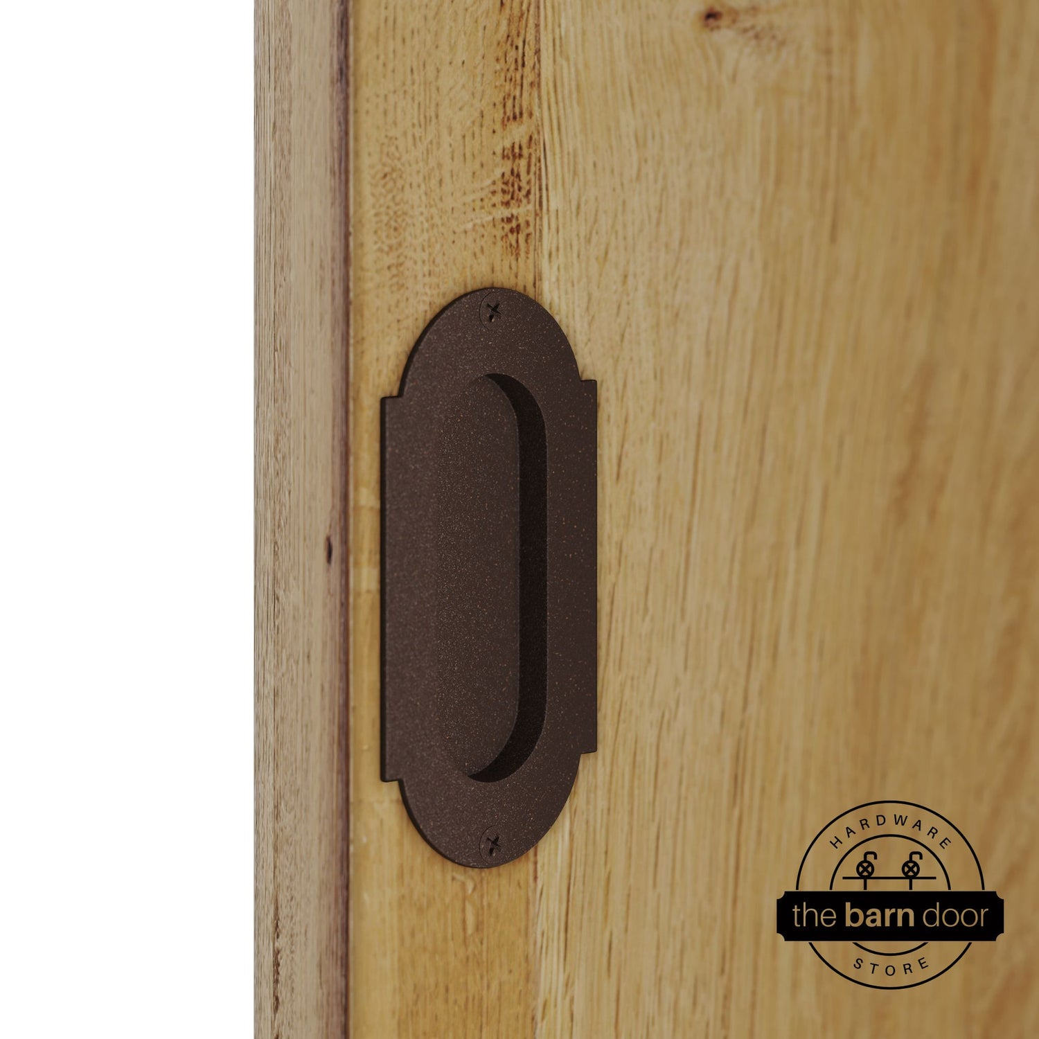 Bronze flush pull handle with full radius wings mounted on a light oak barn door, brushed silver finish with oval recessed grip and four mounting screws