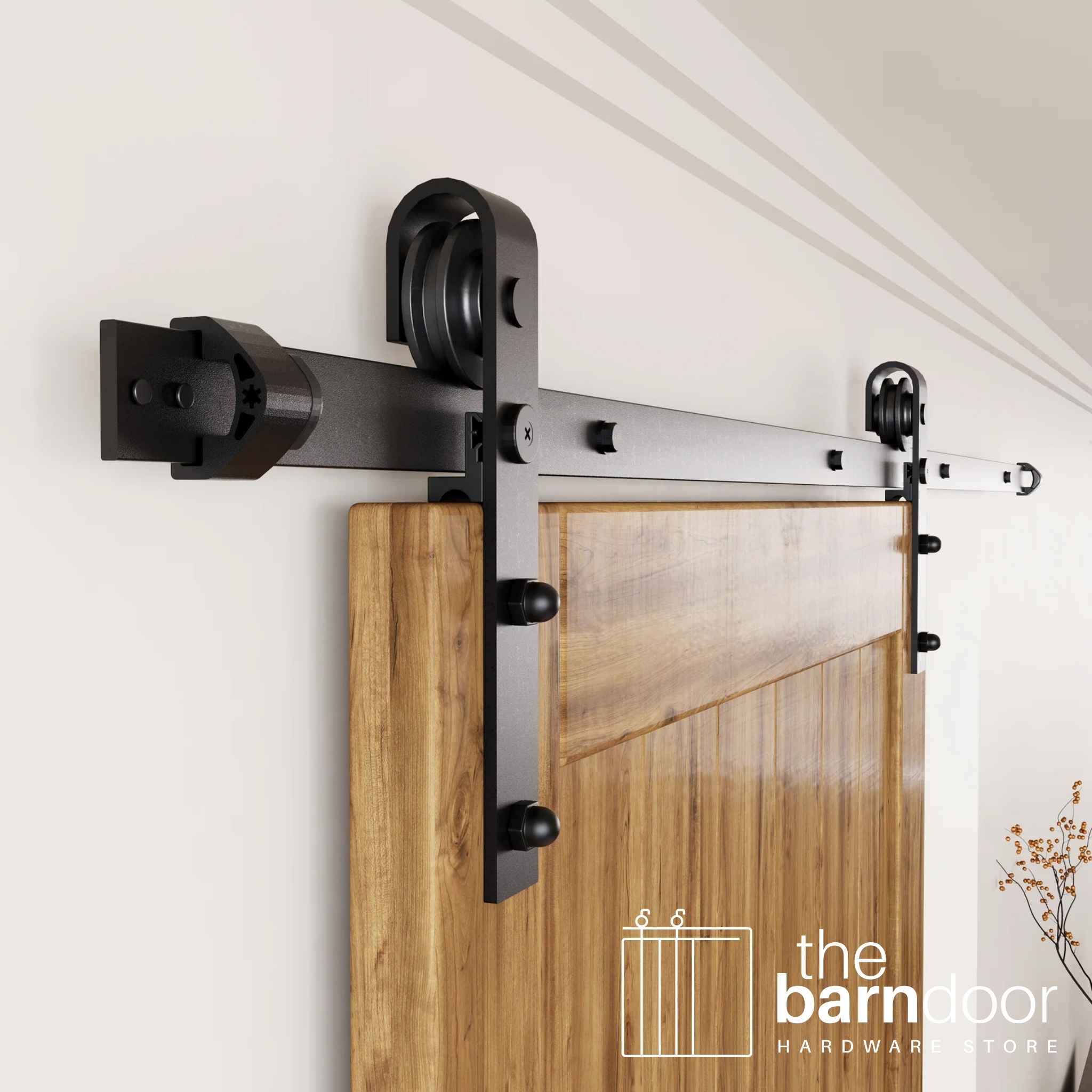An angled close-up of the classic J-strap rollers, smoothly gliding along the track of this black sliding barn door hardware.