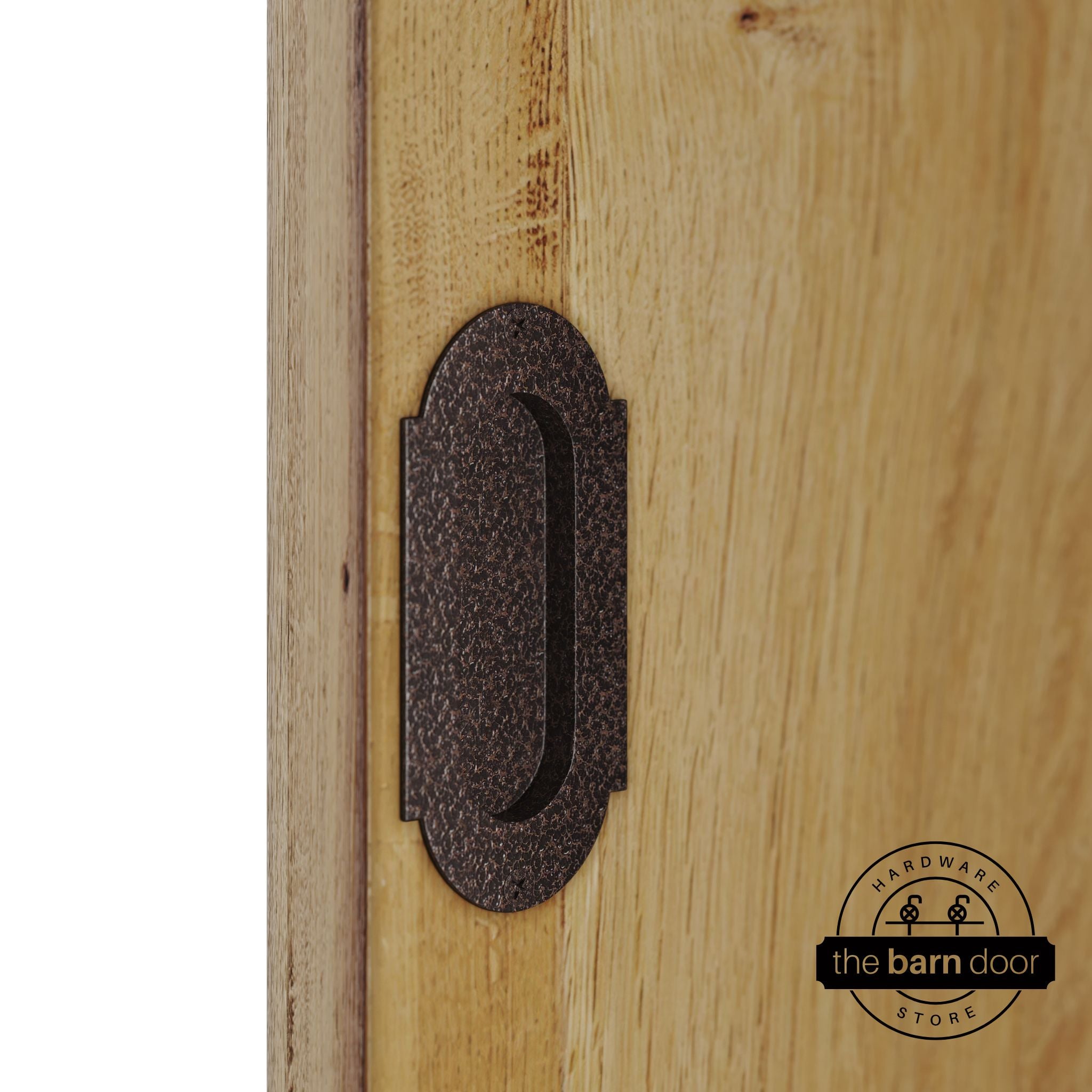 Copper vein flush pull handle with full radius wings mounted on a light oak barn door, brushed silver finish with oval recessed grip and four mounting screws