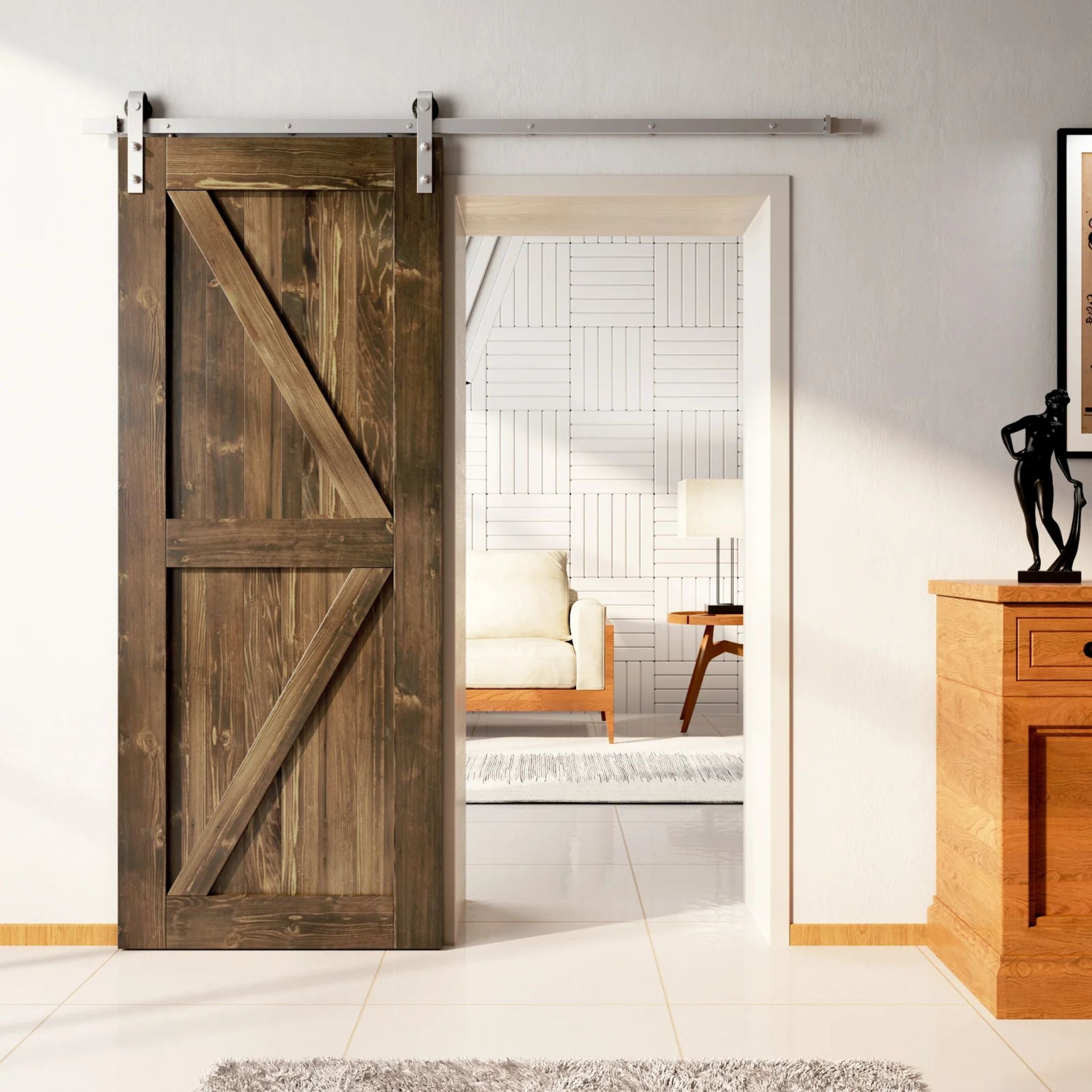 Rustic barn door with a Z-brace design in a medium-dark walnut stain, installed with brushed nickel sliding hardware, partially revealing a living room with white tiled walls.