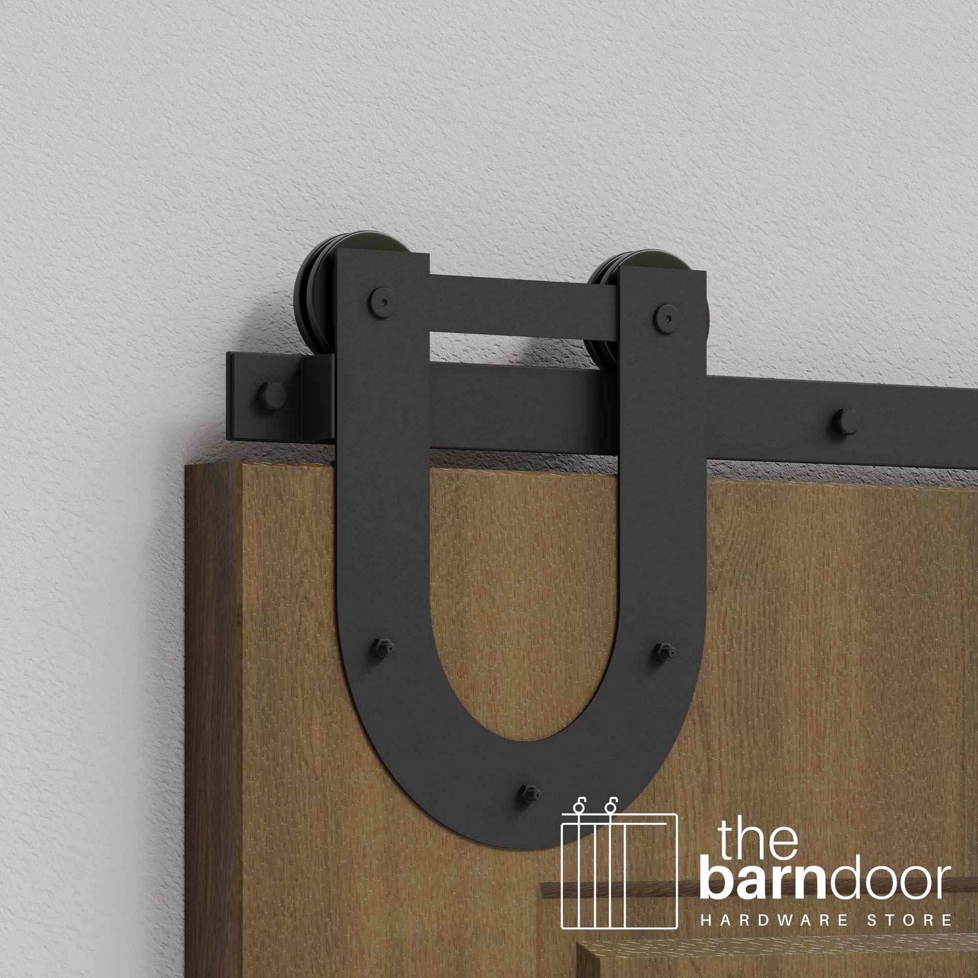 Close-up of Matte Black Horseshoe Single Track barn door hardware installed on a wooden door panel.