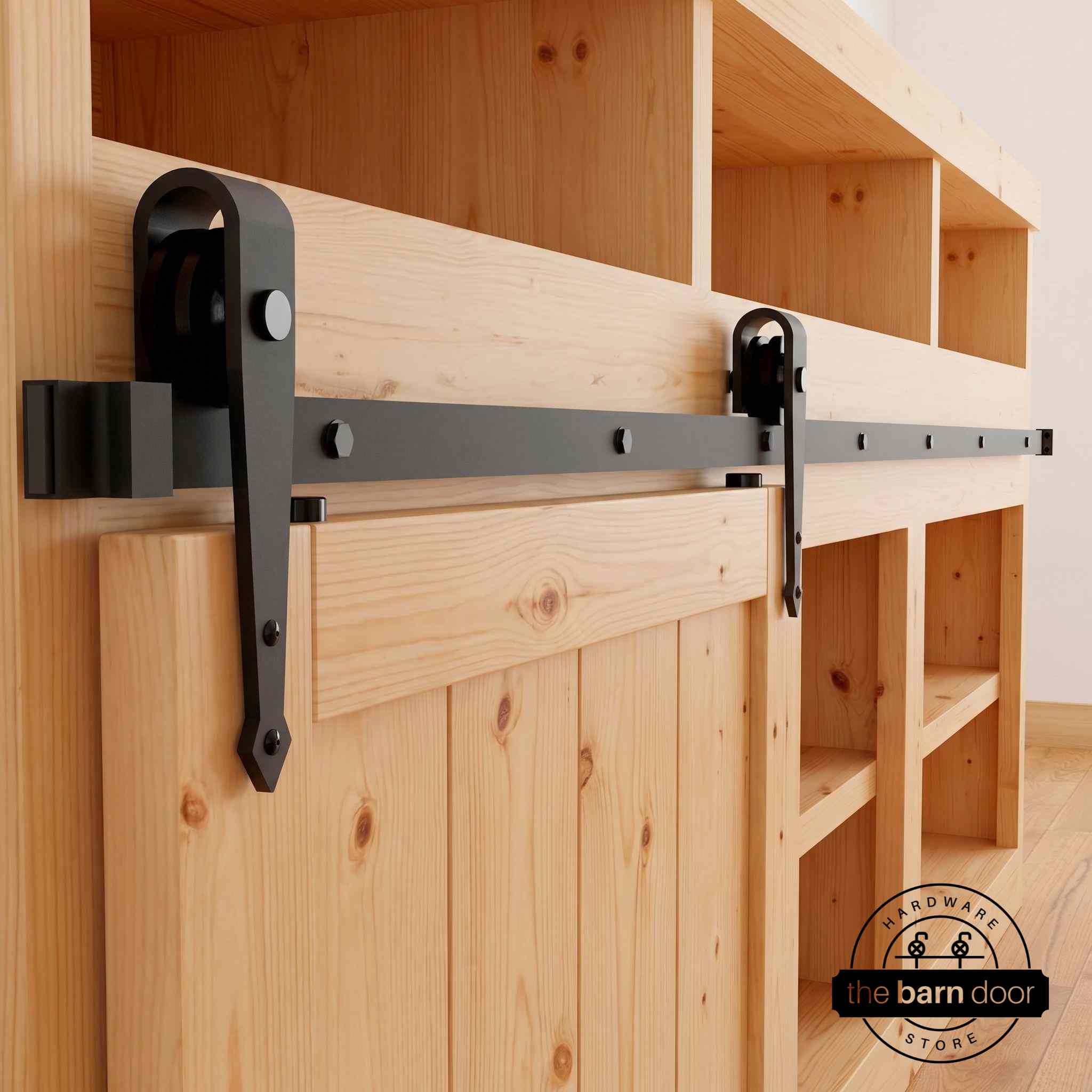 Arrow cabinet barn door hardware kit in matte black with a single track, shown installed on a small wooden cabinet door.