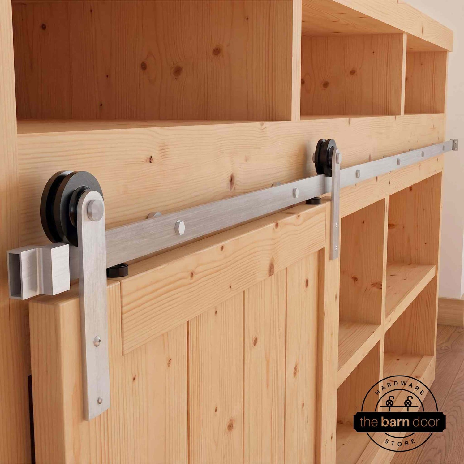 A Straight Strap cabinet barn door hardware kit in a brushed nickel finish, mounted on a small cabinet door.