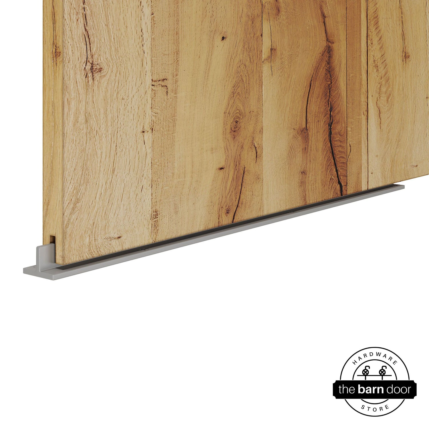 PC Chrome continuous T-guide floor track for barn doors by The Barn Door Hardware Store. Close-up of a heavy-duty bottom floor guide installed on a rustic wood door for stabilization and smooth sliding operation.
