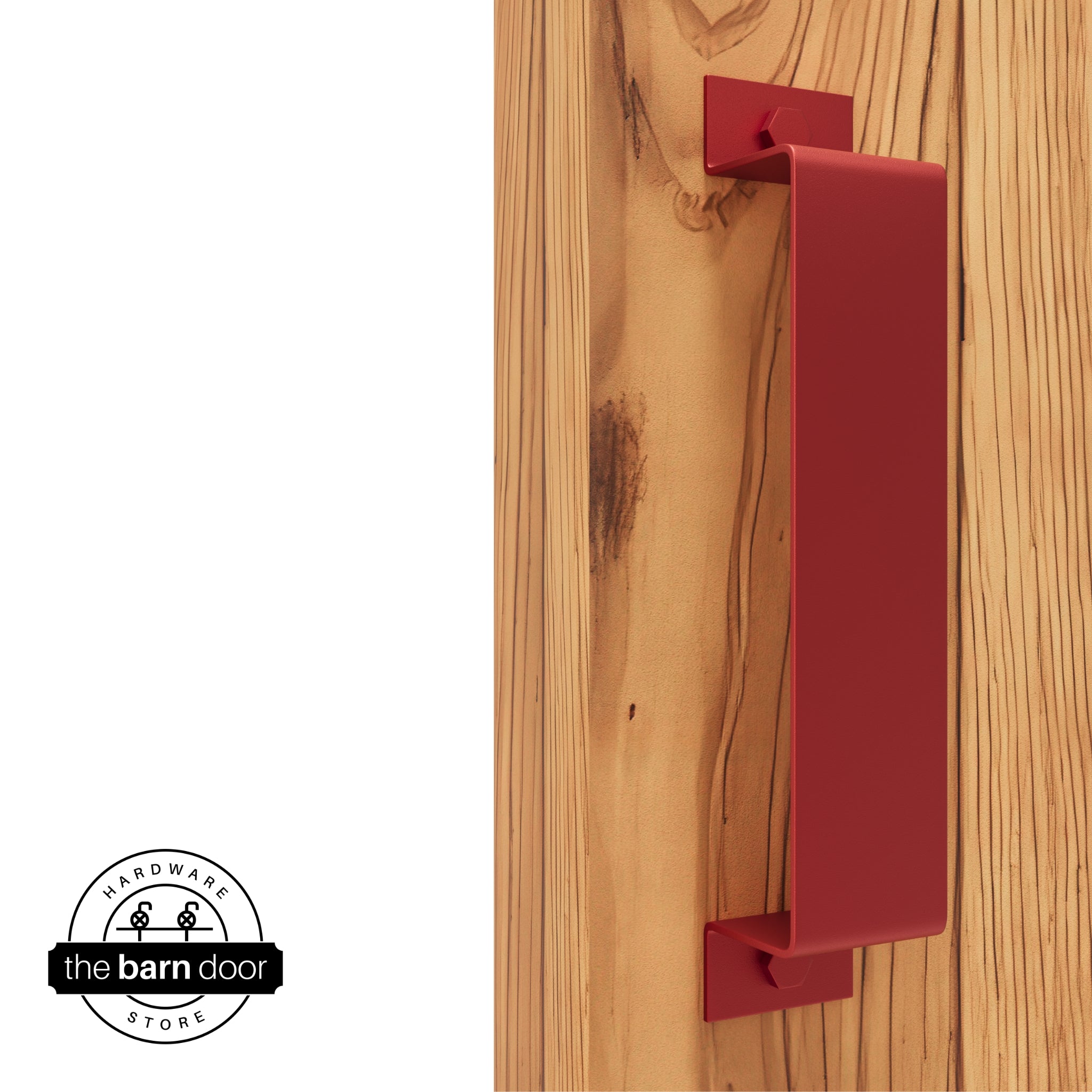 A red, arch-shaped barn door handle is mounted on a light-colored wooden door with a vertical grain pattern.