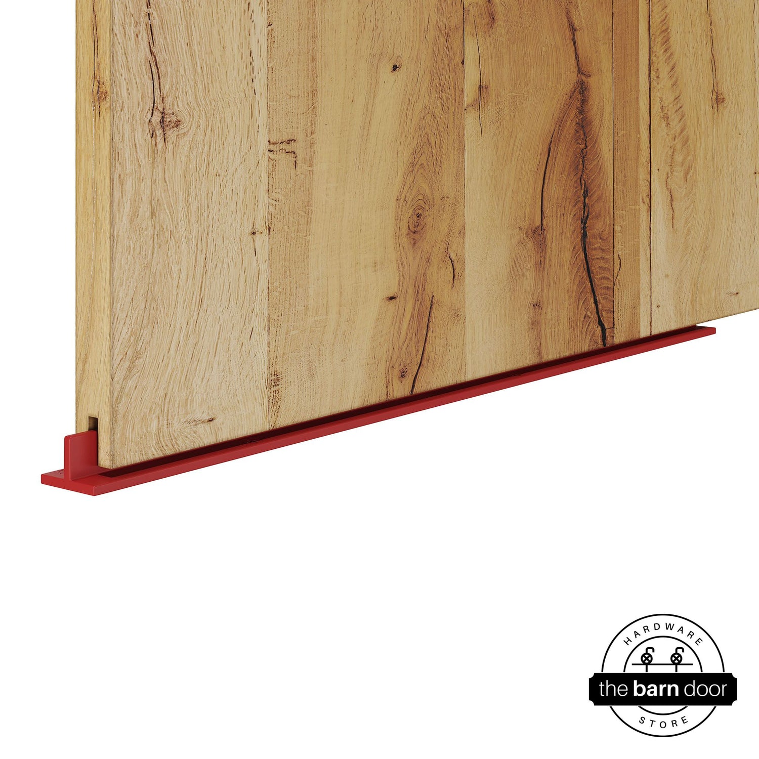 Regal Red continuous T-guide floor track for barn doors by The Barn Door Hardware Store. Close-up of a heavy-duty bottom floor guide installed on a rustic wood door for stabilization and smooth sliding operation.