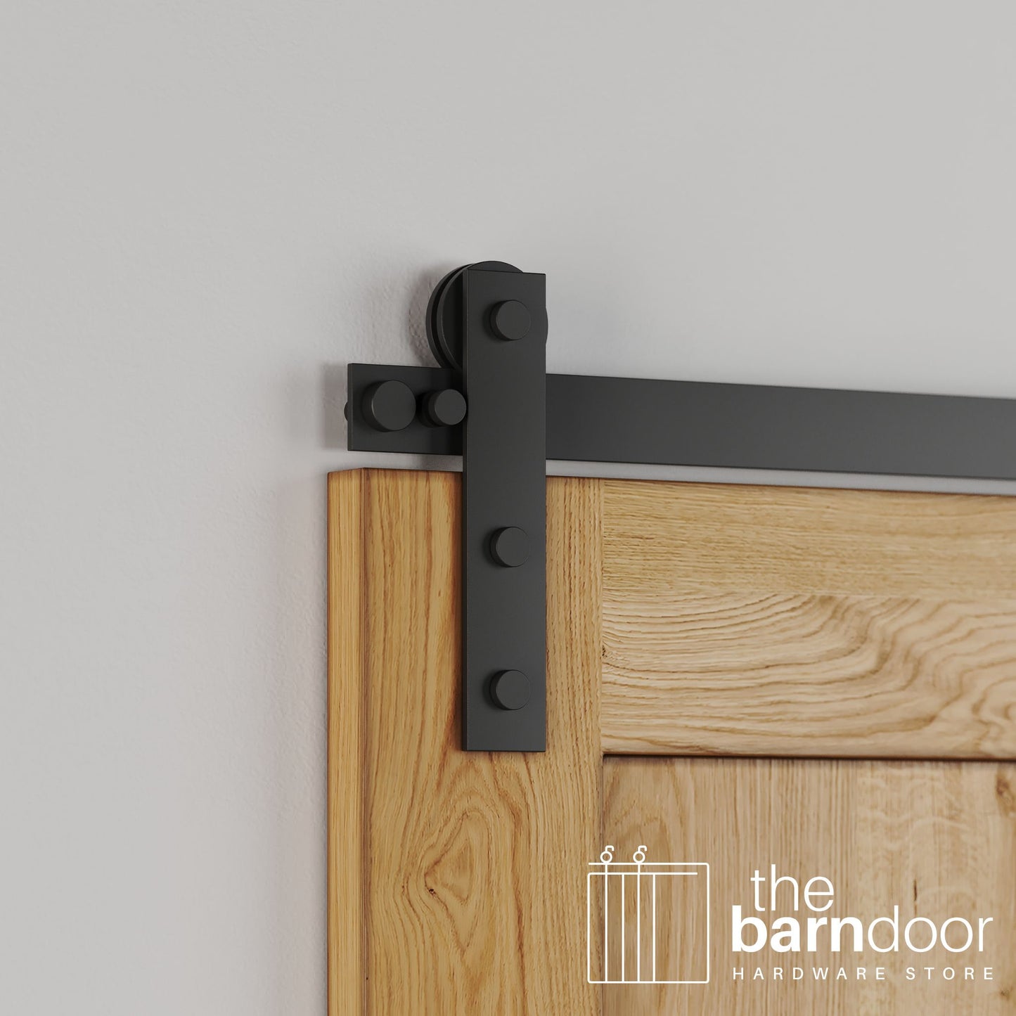 Close-up of Matte Black Stainless Steel Soft-Corner Strap barn door hardware installed on a natural oak wood door, highlighting the dark matte finish and industrial strap design.