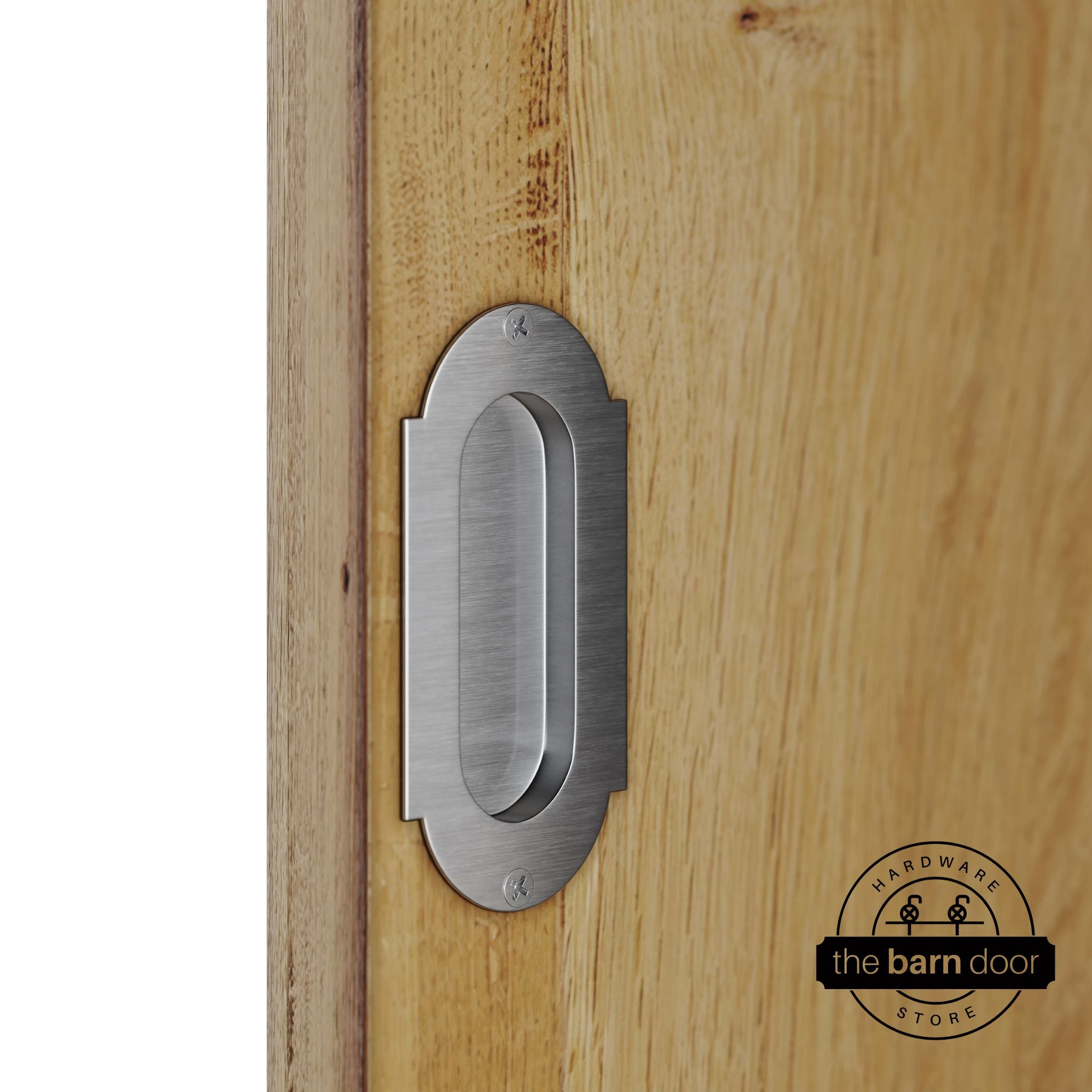 Stainless steel flush pull handle with full radius wings mounted on a light oak barn door, brushed silver finish with oval recessed grip and four mounting screws