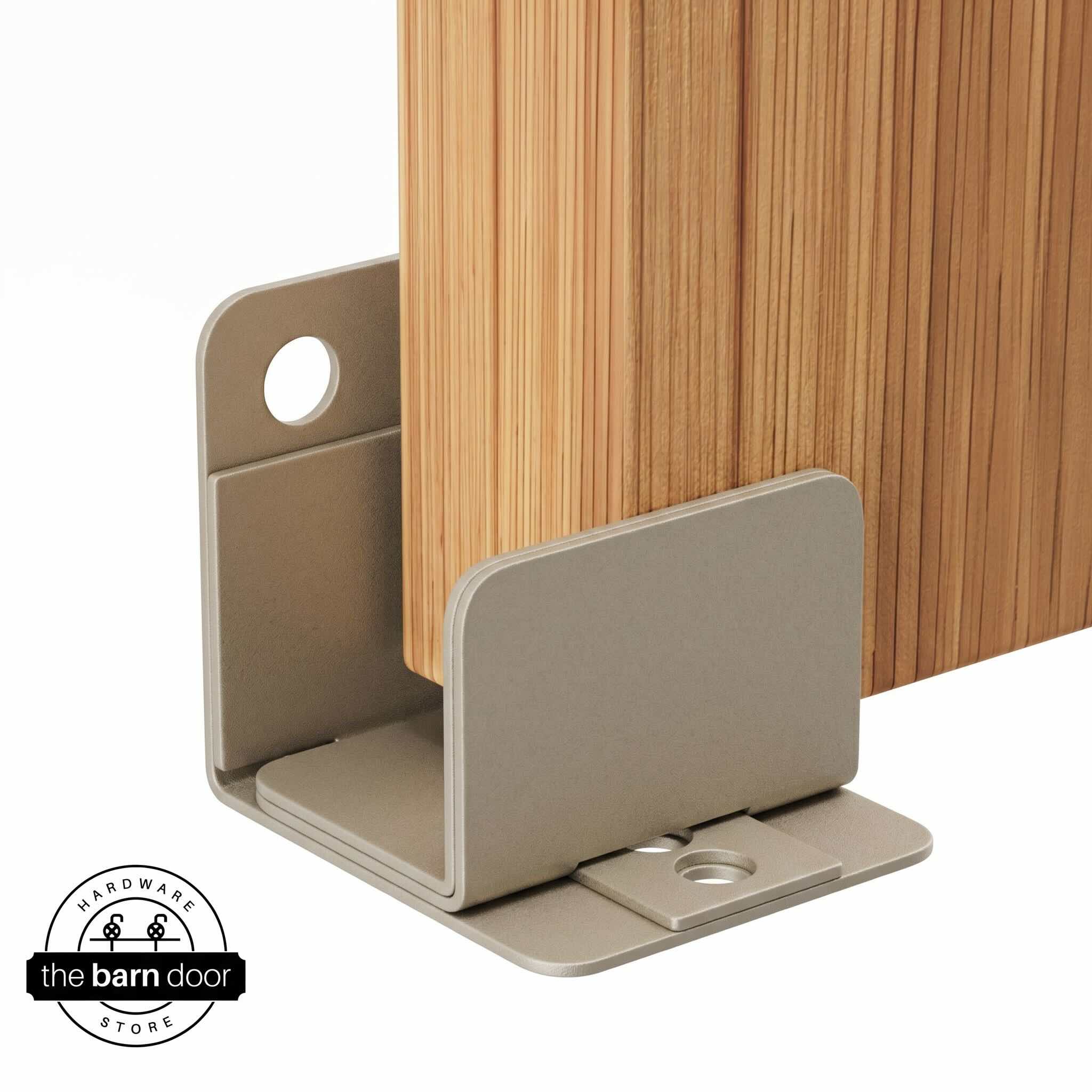 A white bronze U-shaped floor guide with a side plate, holding a light wood barn door in place.