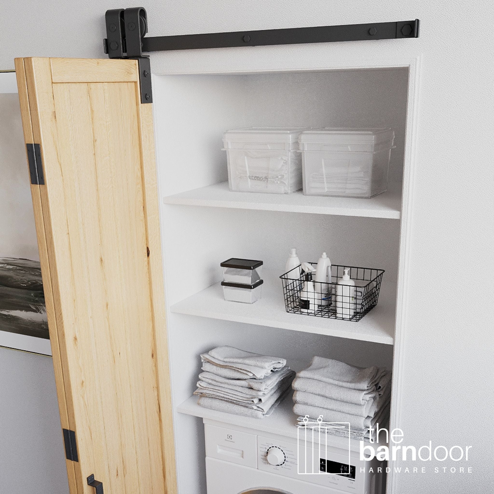 Wooden sliding bifold barn door in a white storage room with shelves and laundry items.