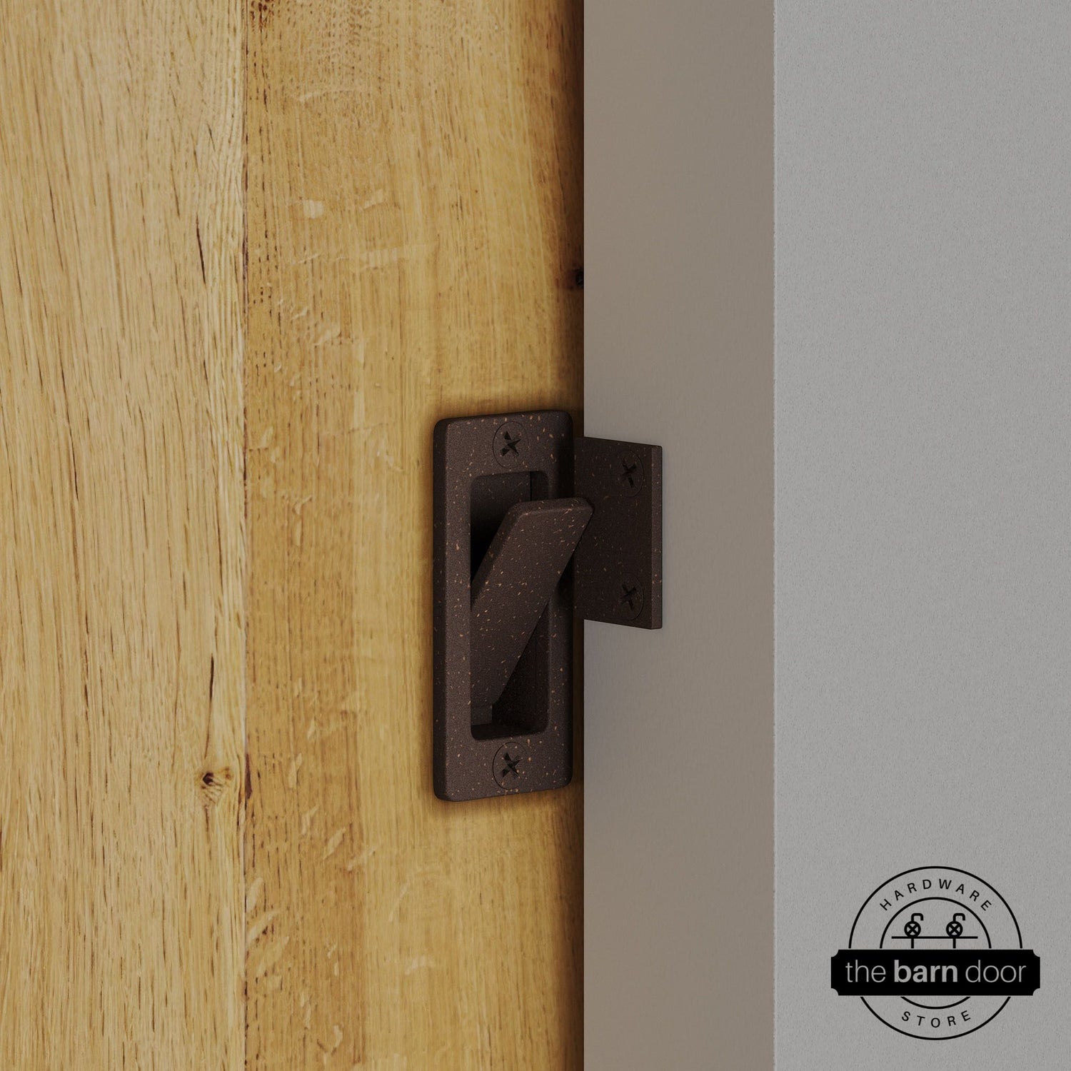 Bronze privacy latch installed on a sliding barn door, shown in the locked position against door frame