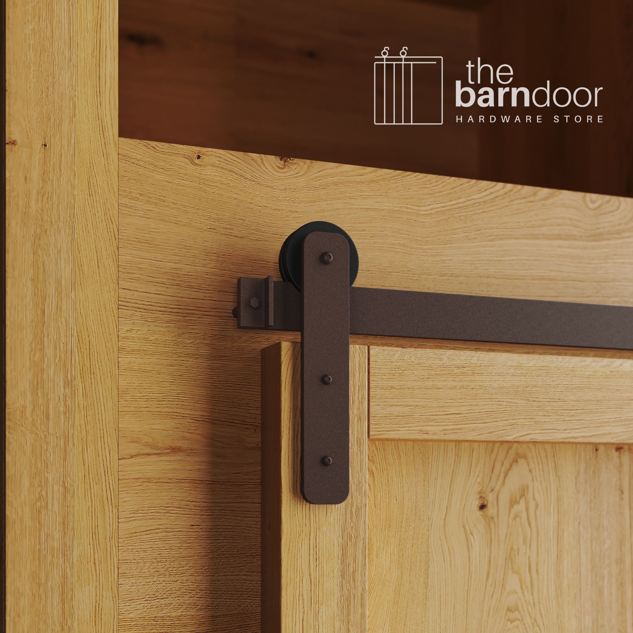 A close-up photograph of a natural oak cabinet with a sliding mini barn door, featuring a bronze straight-strap hanger and a bronze track system.