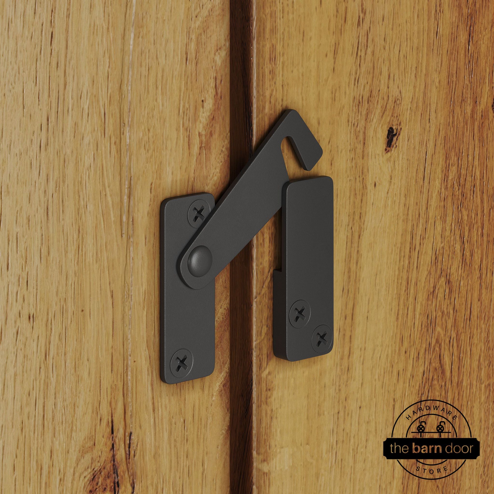 Dark gray privacy latch for biparting barn doors, shown latched across two wood door panels