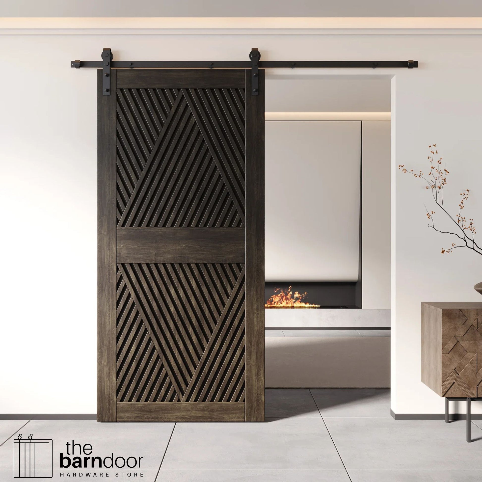 A modern ebony barn door with an intricate geometric diamond pattern installed on a black track in a contemporary living space with a fireplace.