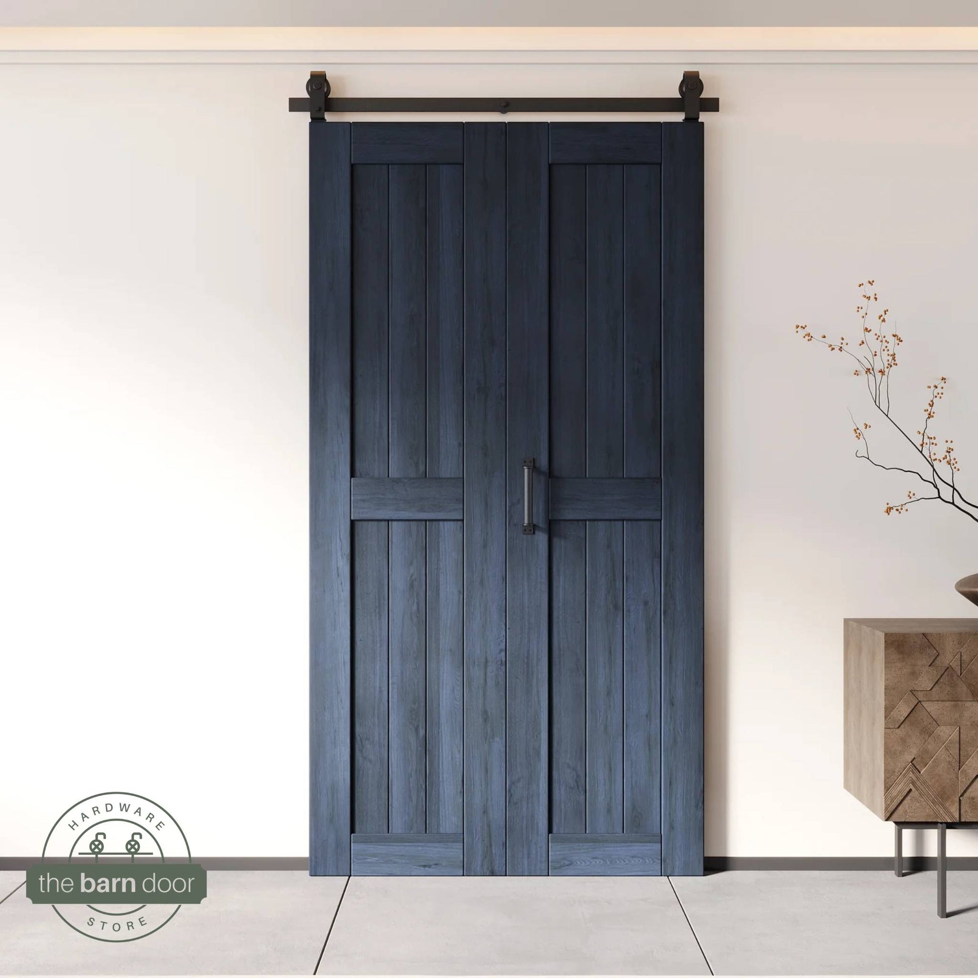 Two-panel bifold barn door in a navy blue finish, installed and fully closed in a modern interior, showing the top-mount Matte Black track.