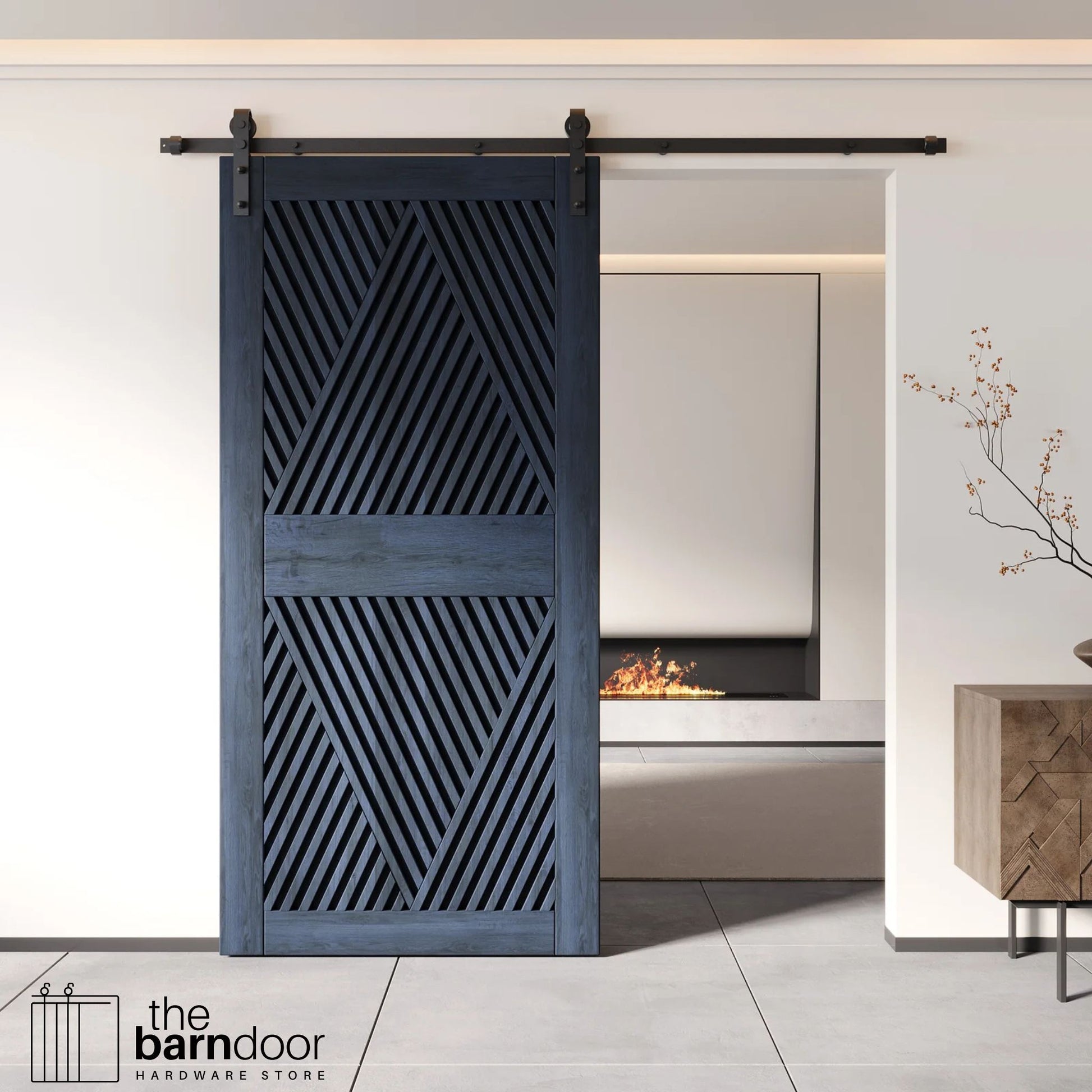A modern navy barn door with an intricate geometric diamond pattern installed on a black track in a contemporary living space with a fireplace.