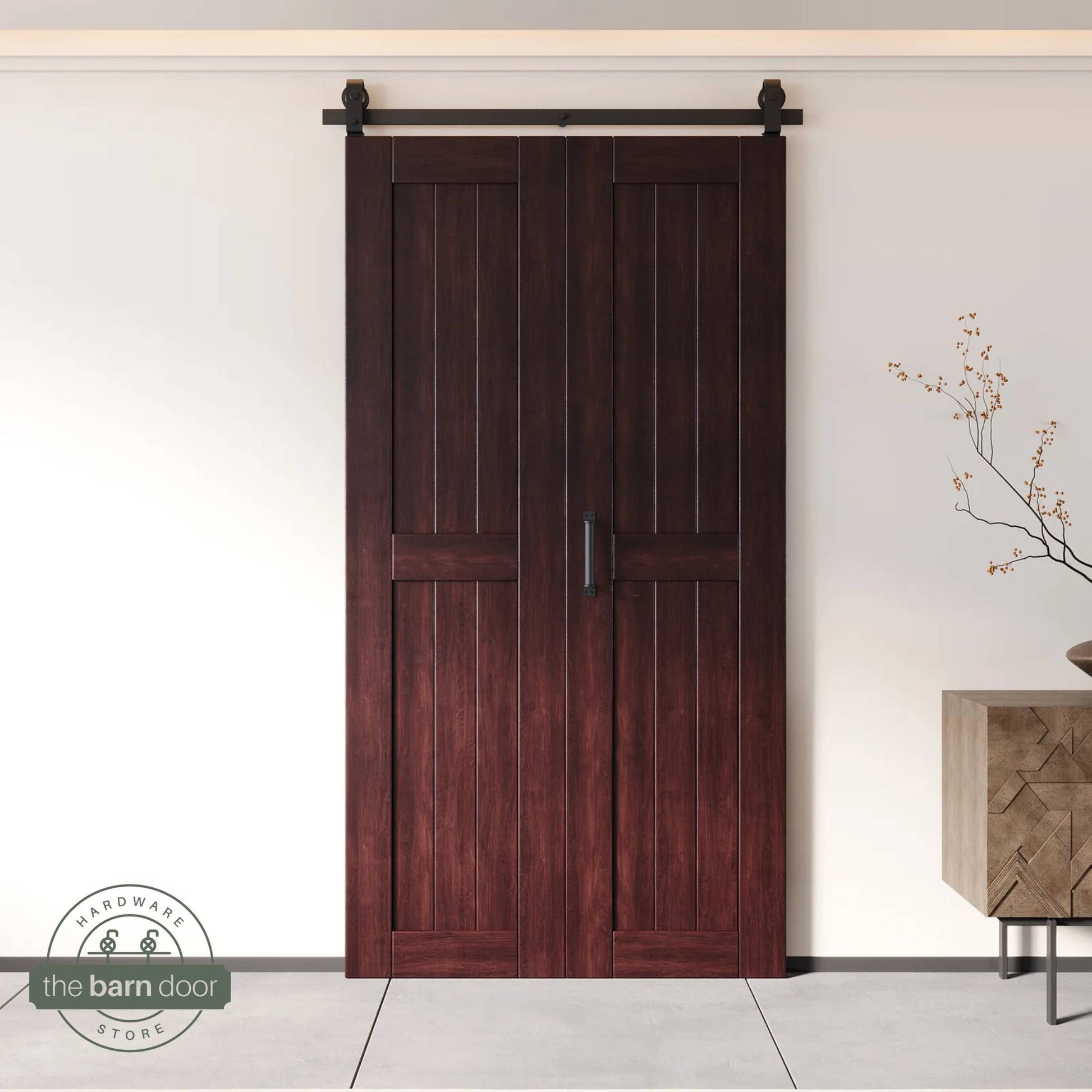 Two-panel bifold barn door in a red mahogany finish, installed and fully closed in a modern interior, showing the top-mount Matte Black track.