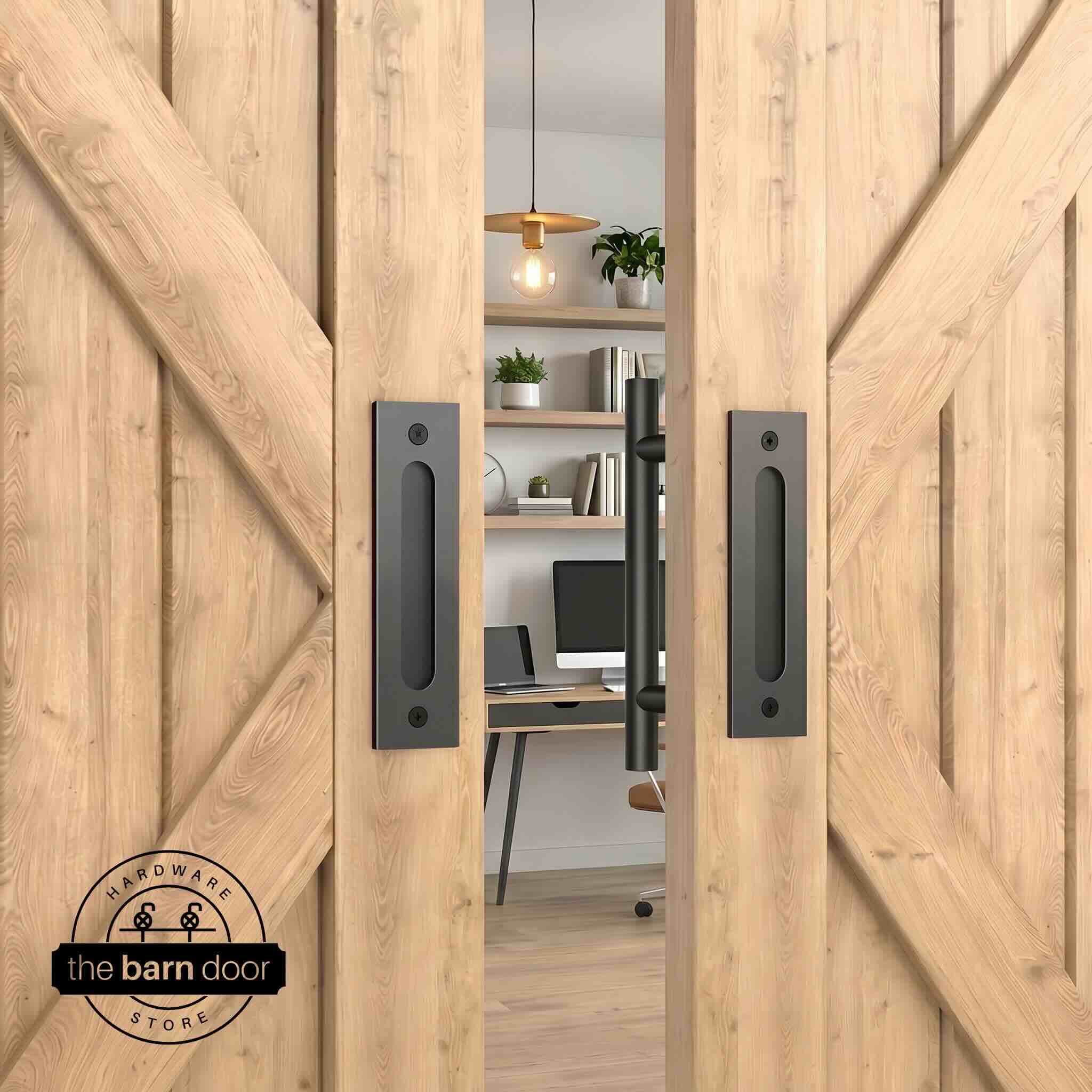 Matte black round pull and flush handle set installed on a white wood sliding barn door