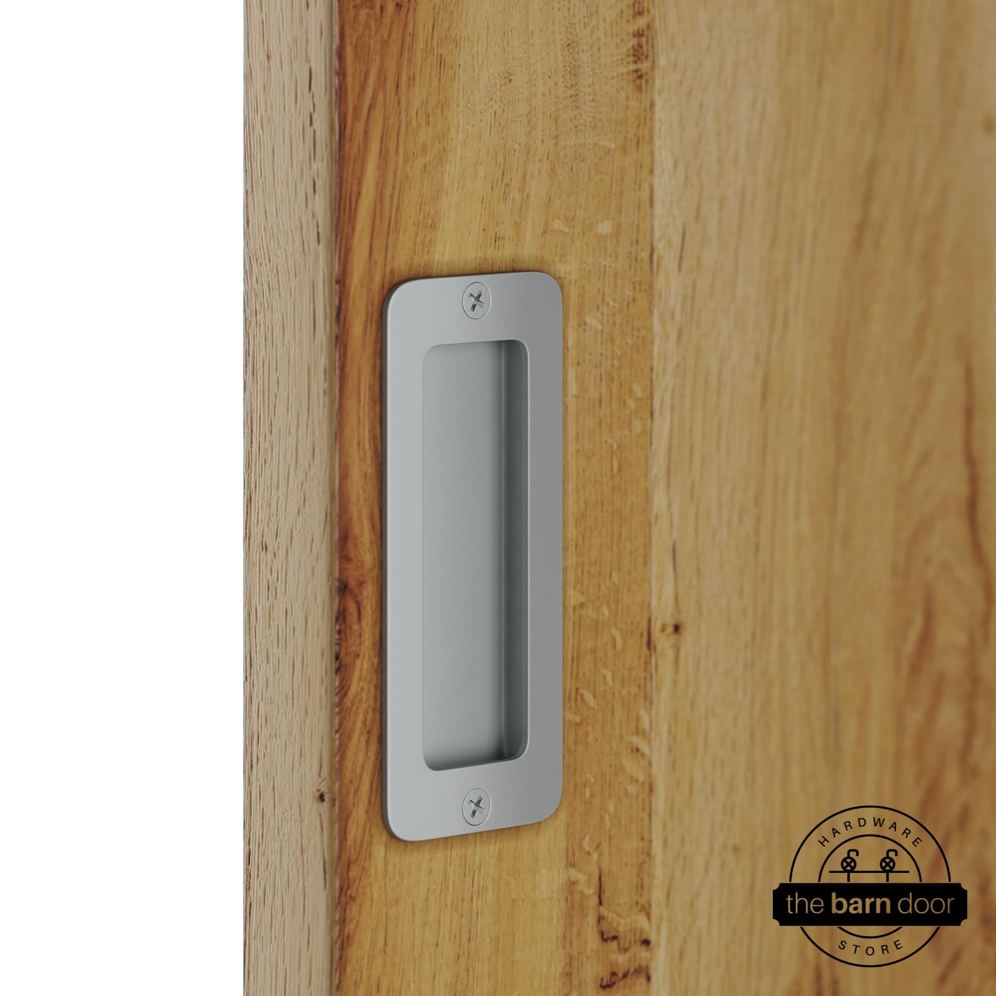 Silver metallic partial radius flush pull handle for sliding barn doors, installed on natural wood door panel