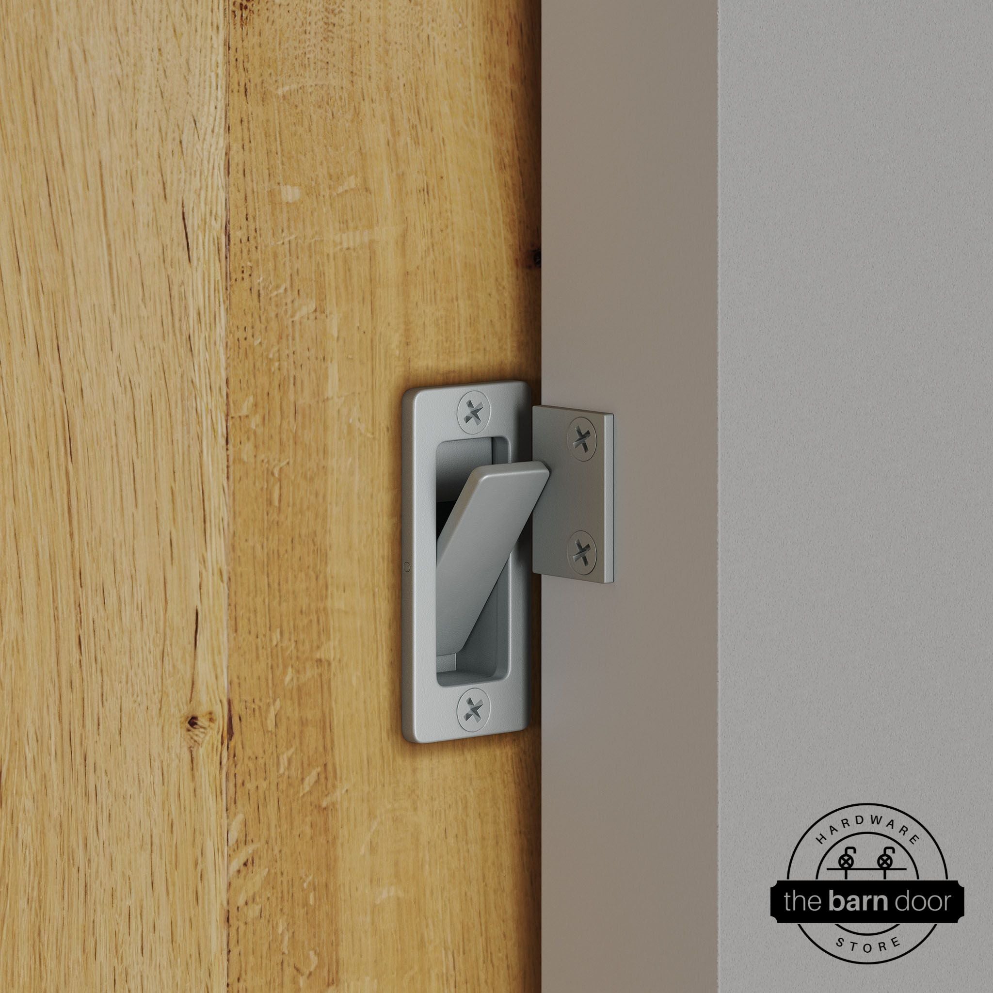 Silver metallic privacy latch installed on a sliding barn door, shown in the locked position against door frame
