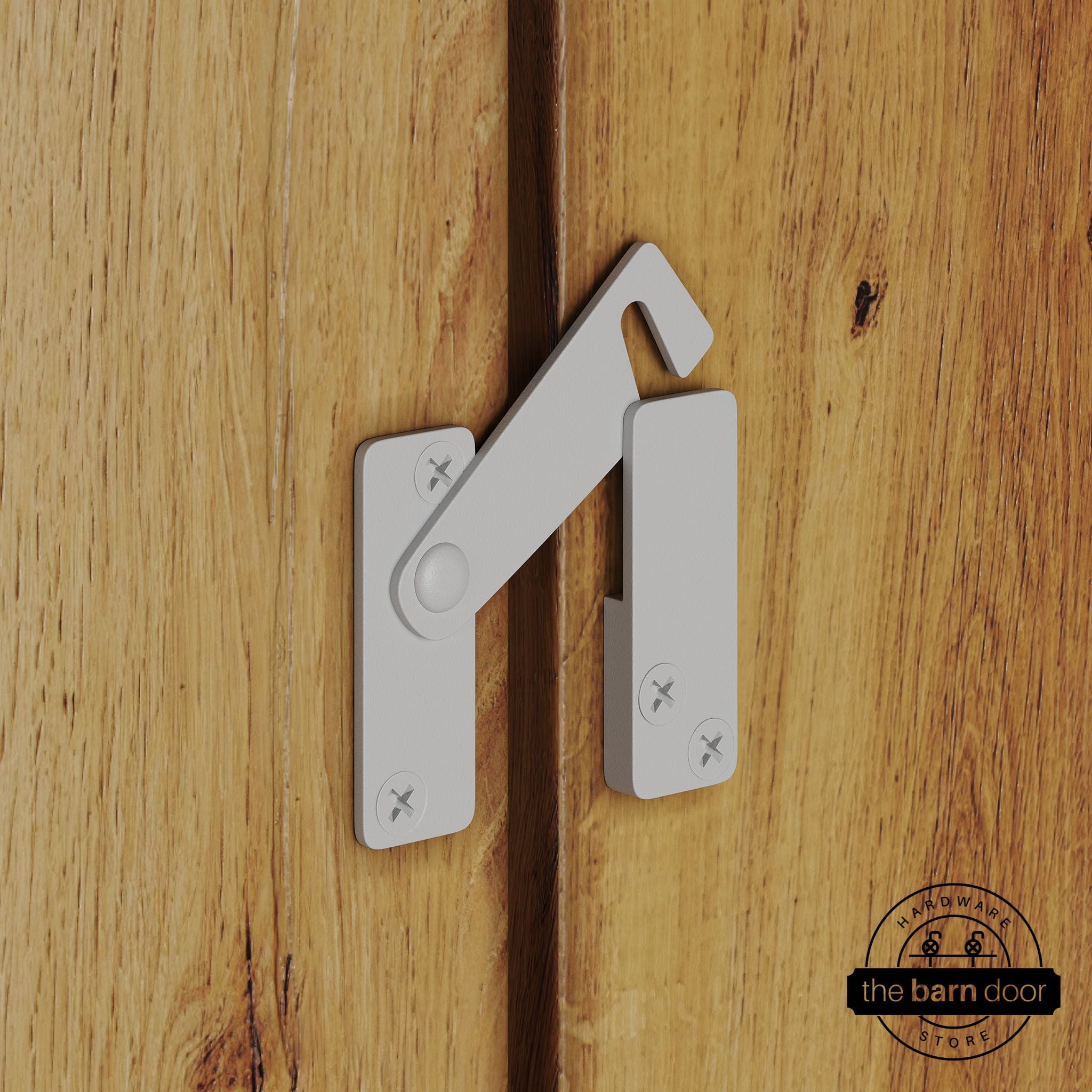 White privacy latch for biparting barn doors, shown latched across two wood door panels