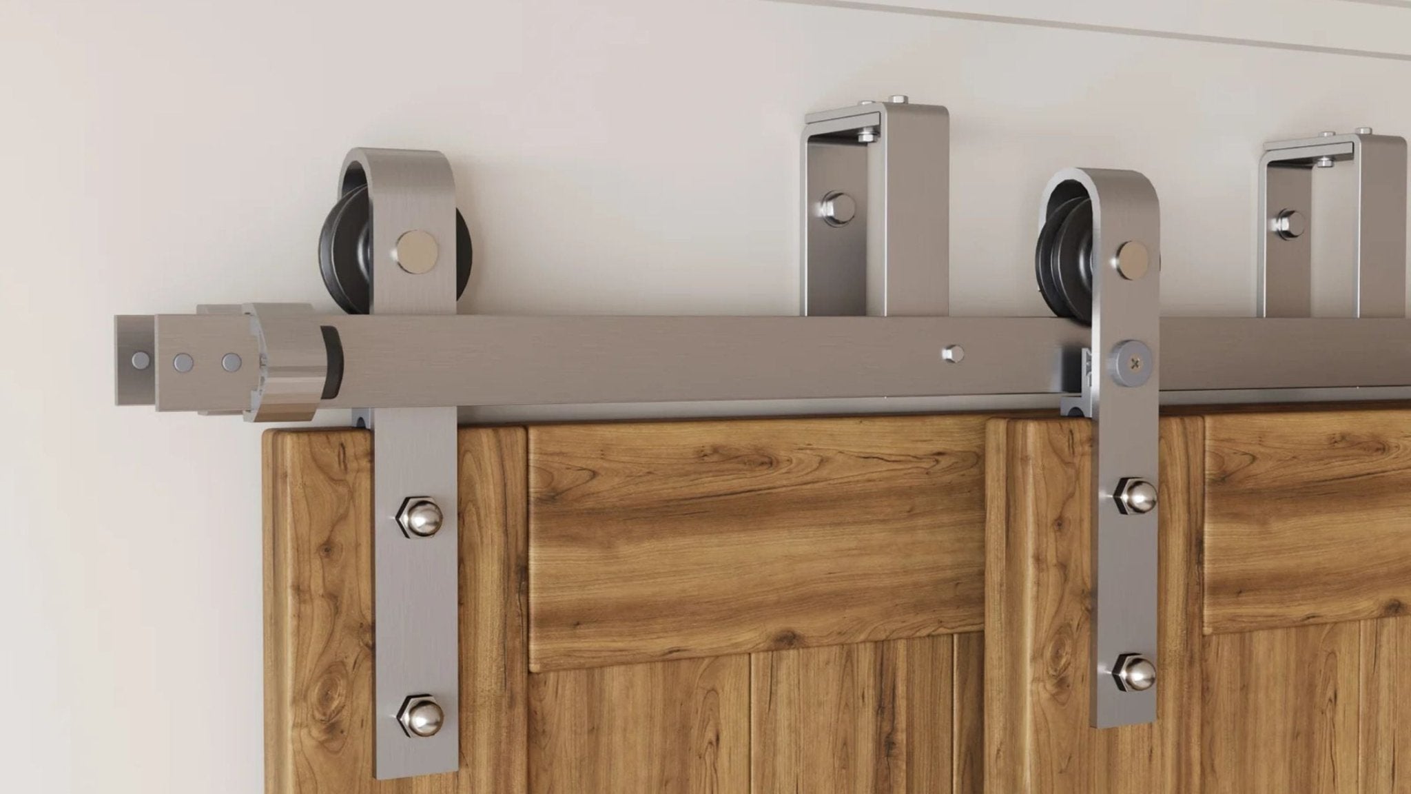 A close-up image of a double bypass barn door track, featuring two parallel steel rails and the bypass brackets that allow doors to slide past each other.