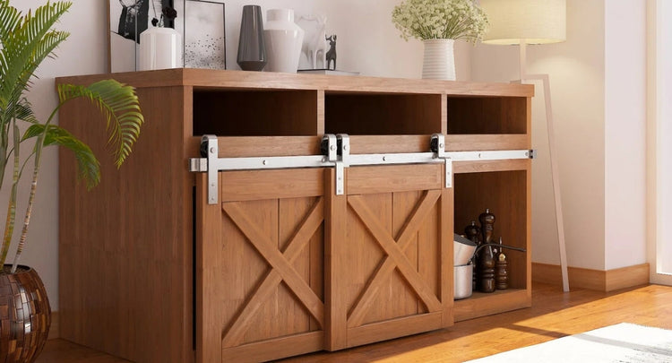 A wood cabinet with a X brace pattern, featuring a classic J-strap style single bypass barn door hardware kit in a brushed nickel finish.