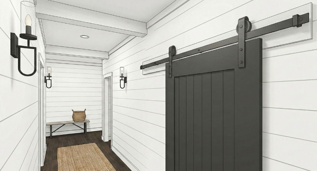 A modern farmhouse hallway featuring a matte black vertical-panel barn door. The door is mounted on a black bent-strap track system against clean white shiplap walls, accompanied by matching black wall sconces.