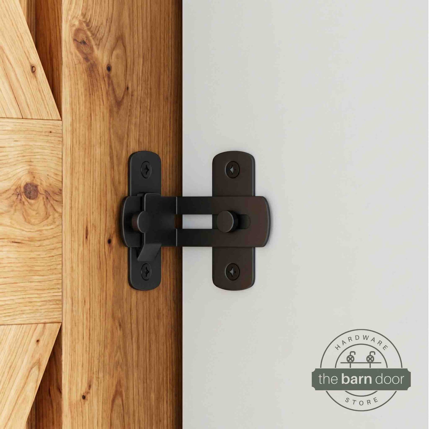 Matte black 90-degree barn door latch installed on a sliding barn door and white wall