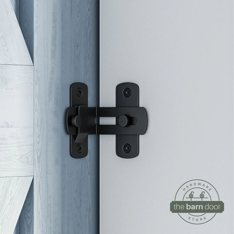 Matte black 90-degree barn door latch installed on a sliding barn door and white wall