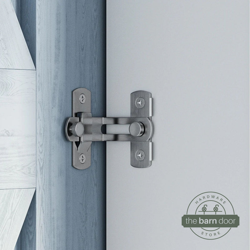 Stainless steel 90-degree barn door latch installed on a sliding barn door and white wall