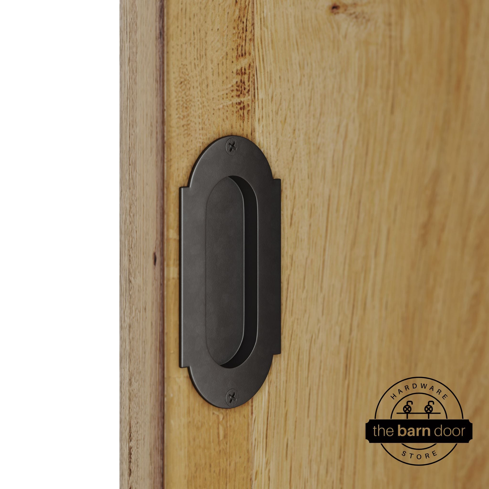 Arch bronze flush pull handle with full radius wings mounted on a light oak barn door, brushed silver finish with oval recessed grip and four mounting screws