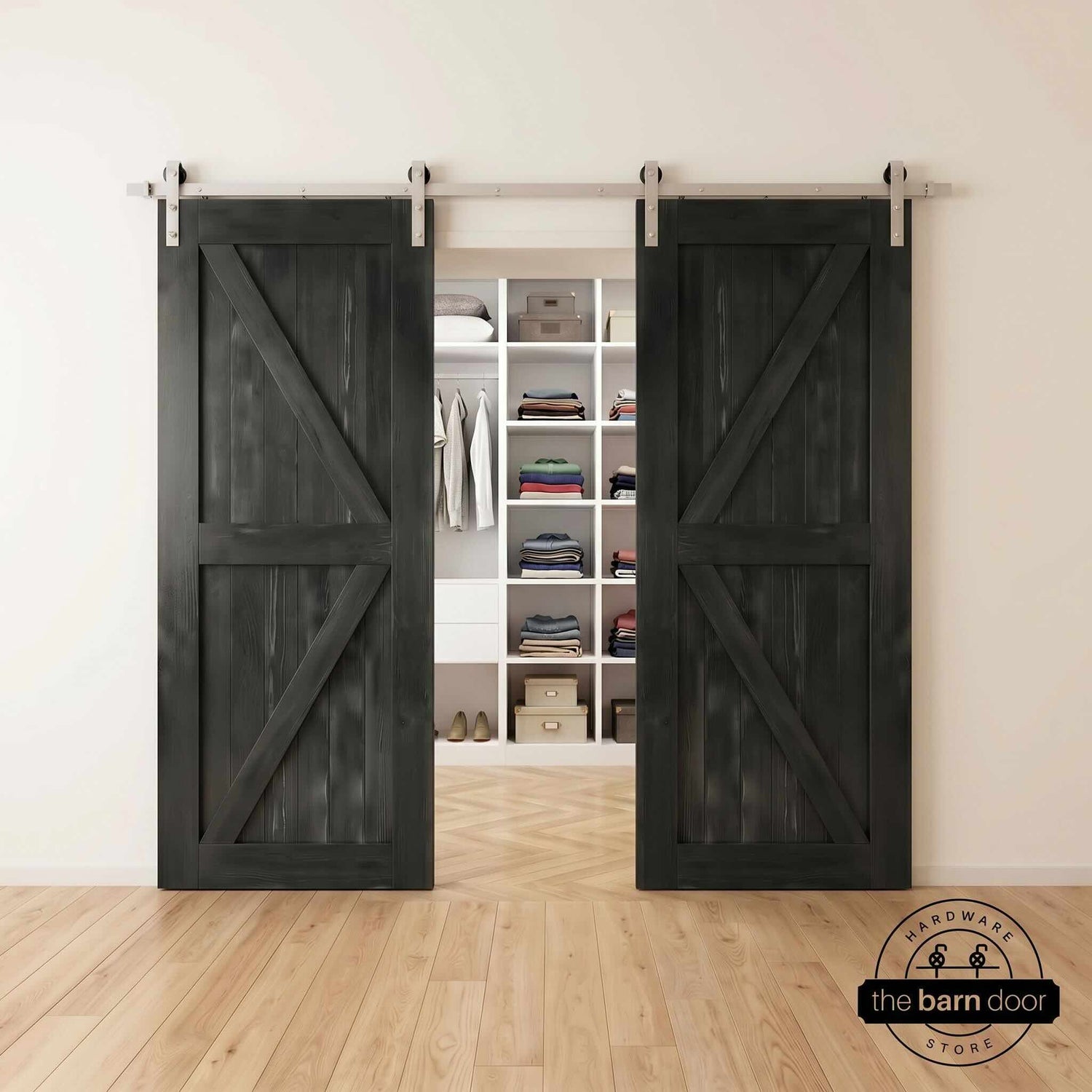 Two wood double barn doors with a two-panel vertical plank design in a black stain, installed with brushed nickel sliding hardware, partially revealing a living room area.