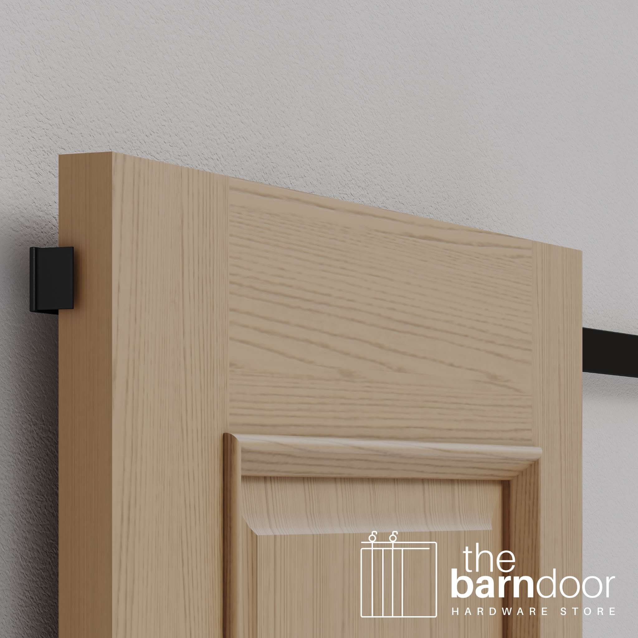 A close-up of the discreet, black wall-mounted guide, showing the matte black finish available for our minimalist barn door hardware.