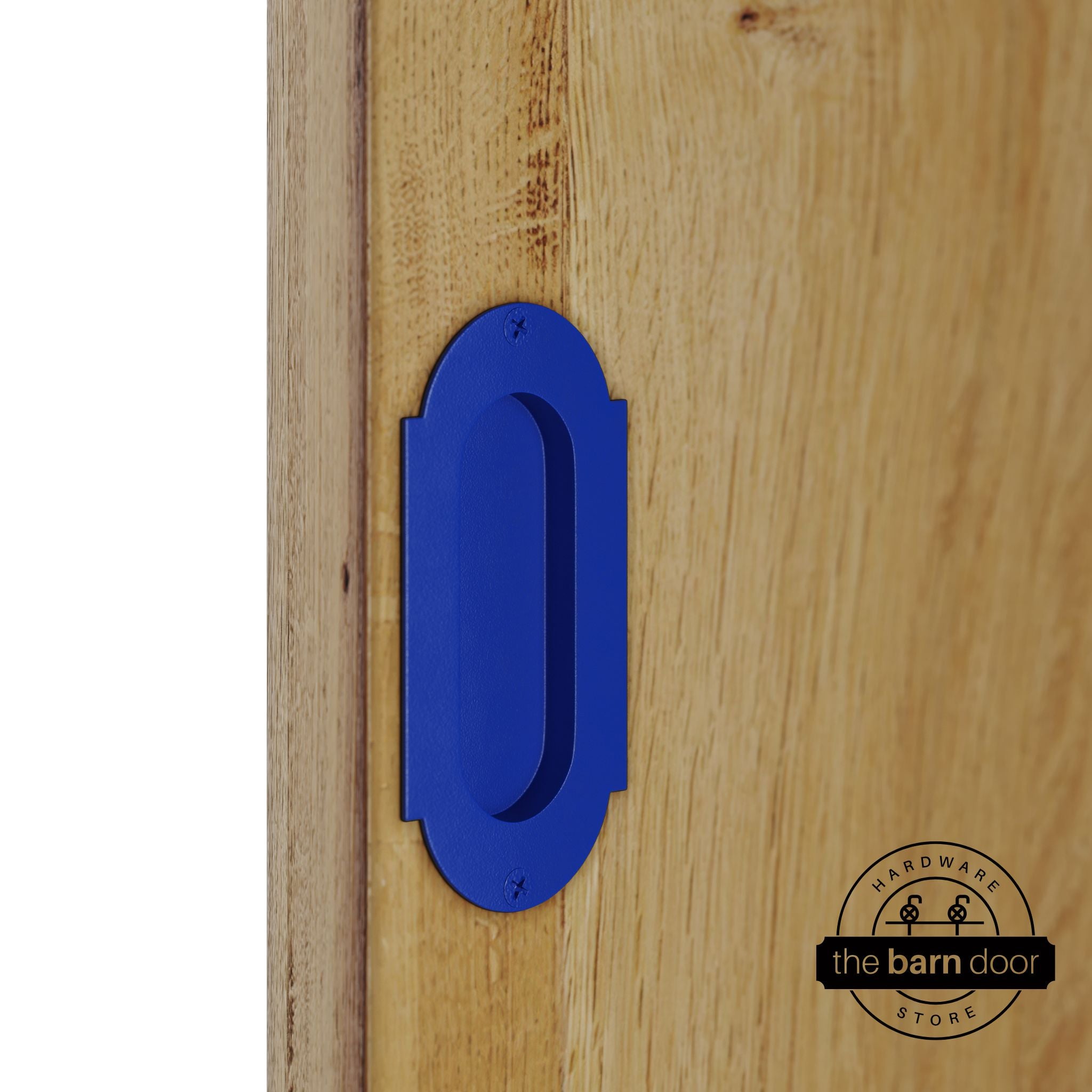 Blue flush pull handle with full radius wings mounted on a light oak barn door, brushed silver finish with oval recessed grip and four mounting screws