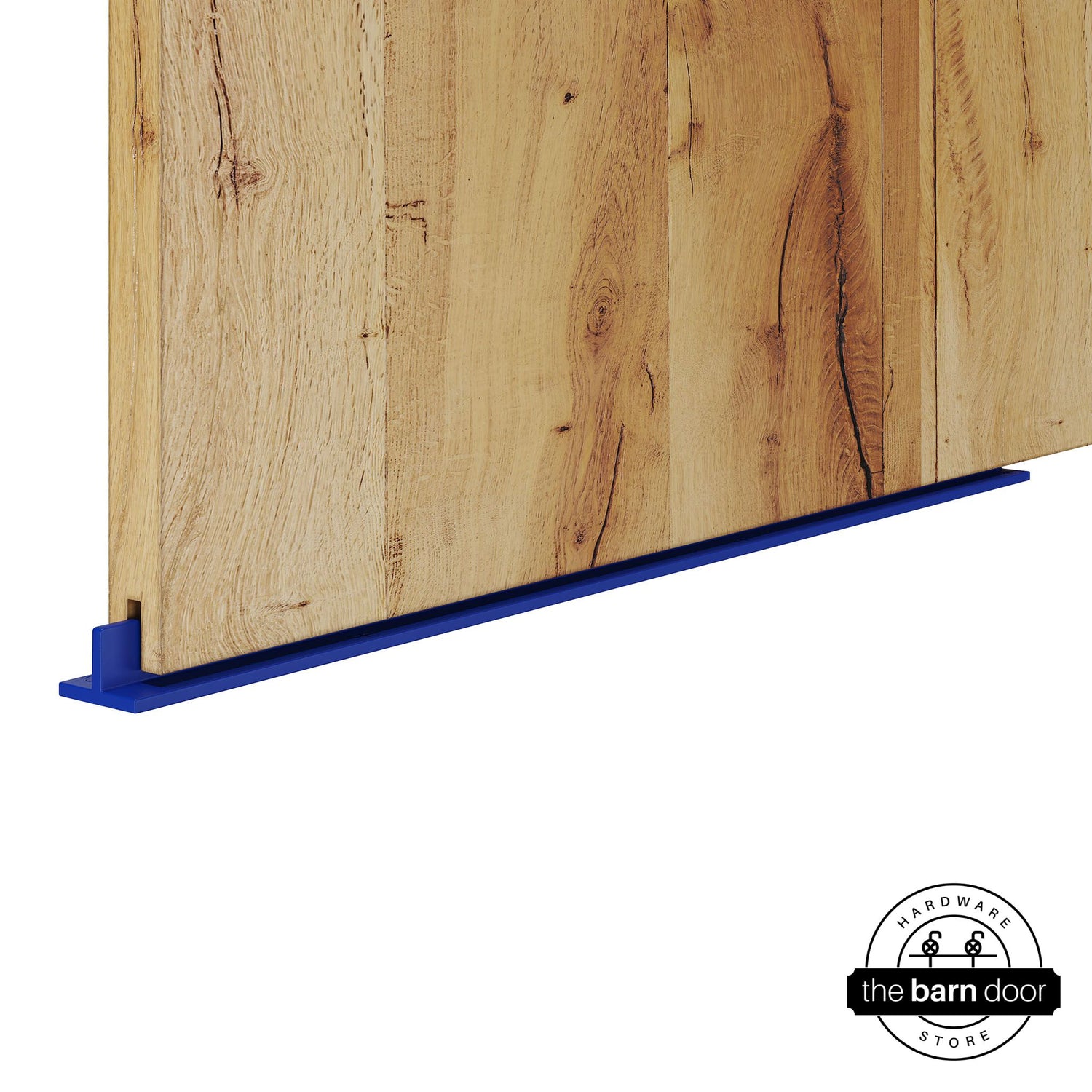 Blue continuous T-guide floor track for barn doors by The Barn Door Hardware Store. Close-up of a heavy-duty bottom floor guide installed on a rustic wood door for stabilization and smooth sliding operation.