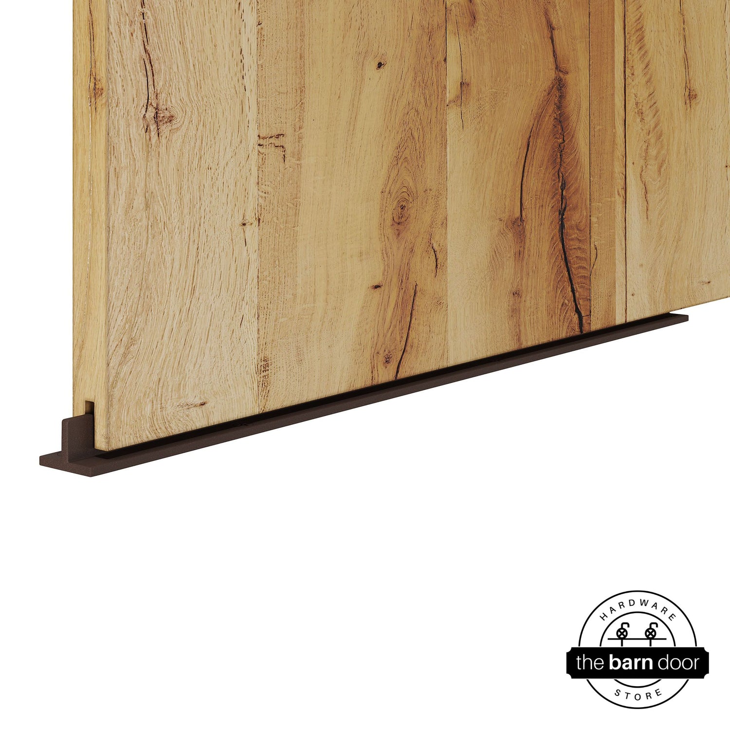 Bronze continuous T-guide floor track for barn doors by The Barn Door Hardware Store. Close-up of a heavy-duty bottom floor guide installed on a rustic wood door for stabilization and smooth sliding operation.