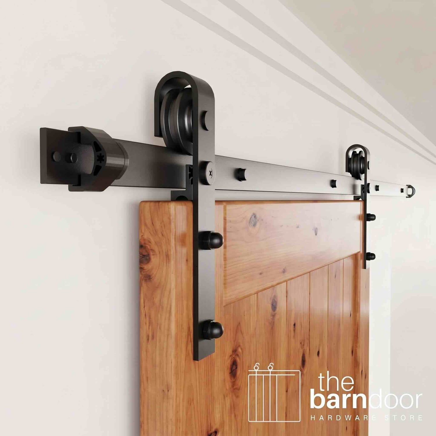 An angled close-up of the classic J-strap rollers, smoothly gliding along the track of this black sliding barn door hardware.