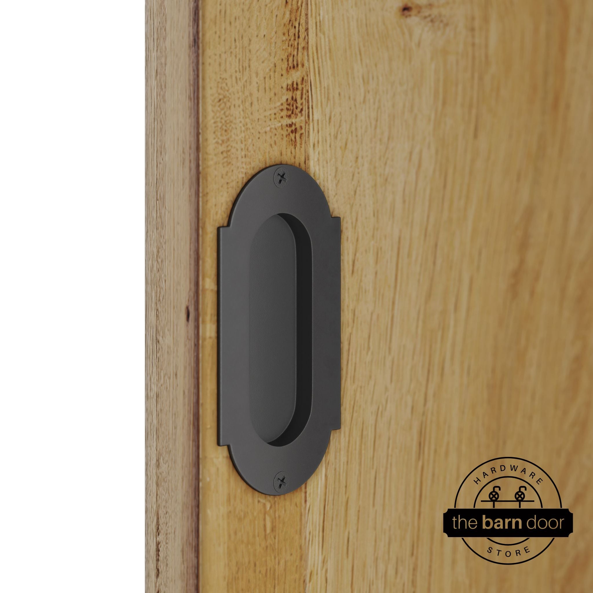 Dark gary flush pull handle with full radius wings mounted on a light oak barn door, brushed silver finish with oval recessed grip and four mounting screws