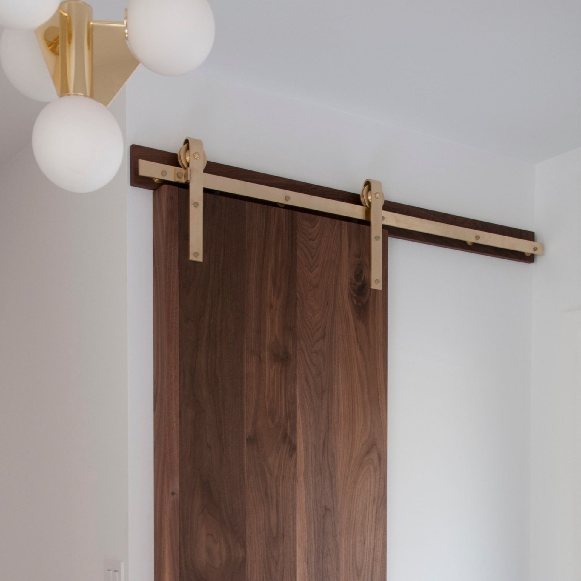 Face Mount Brass Barn Door Hardware on Dark Walnut Door