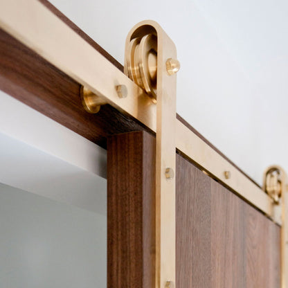 Face Mount Brass Barn Door Hardware on Dark Walnut Door Close Up