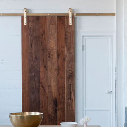 Face Mount Brass Barn Door Hardware on Dark Walnut Door in Kitchen