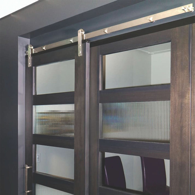 Straight Strap stainless steel barn door hardware kit installed on a single wood door, highlighting the sleek, minimalist roller design.