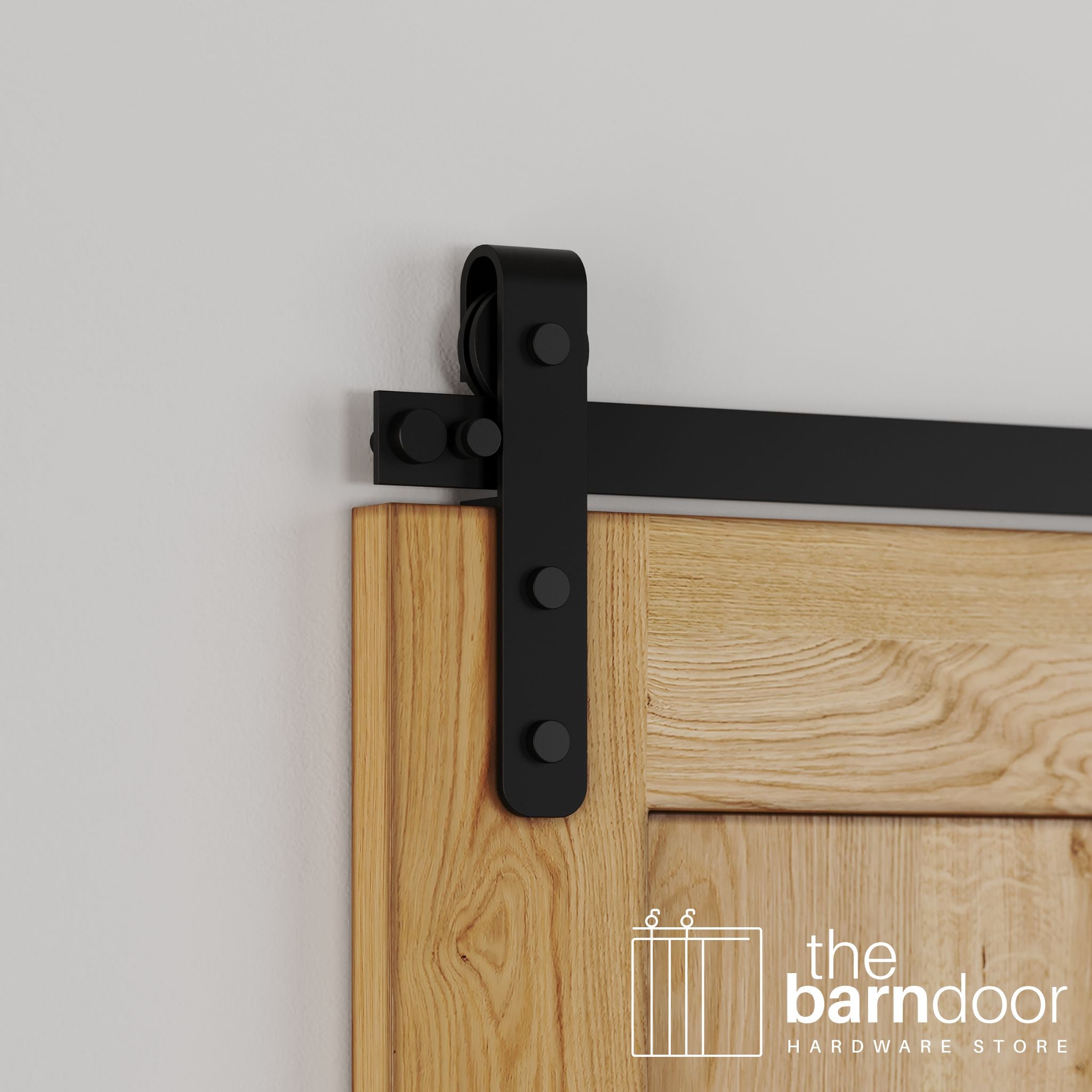 Close-up of classic Black Stainless Steel J-Strap barn door hardware installed on a natural wood door, showing the curved roller.