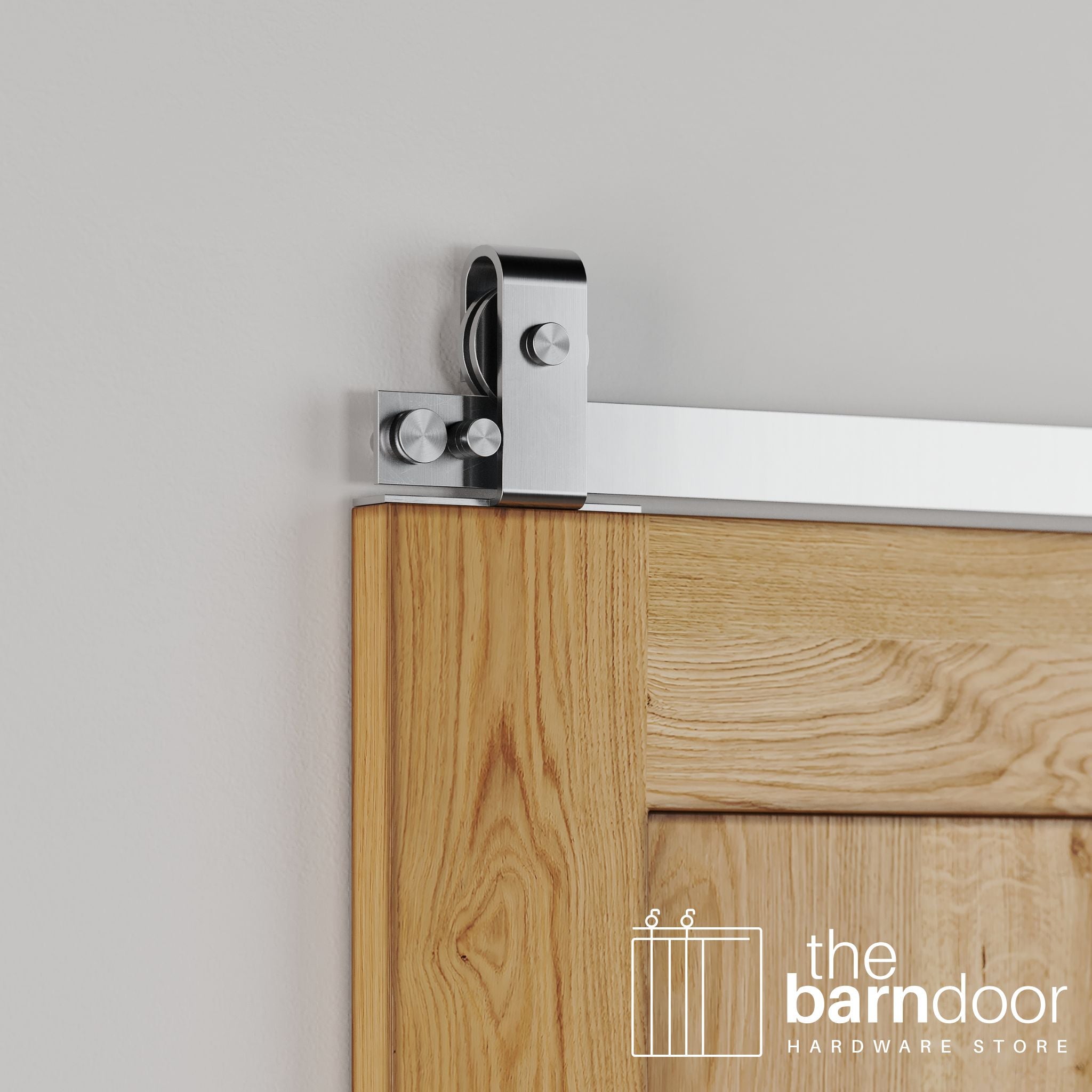 Close-up of Stainless Steel J Top Mount barn door hardware installed on the top edge of a natural wood door, highlighting the sleek, contemporary metal finish.