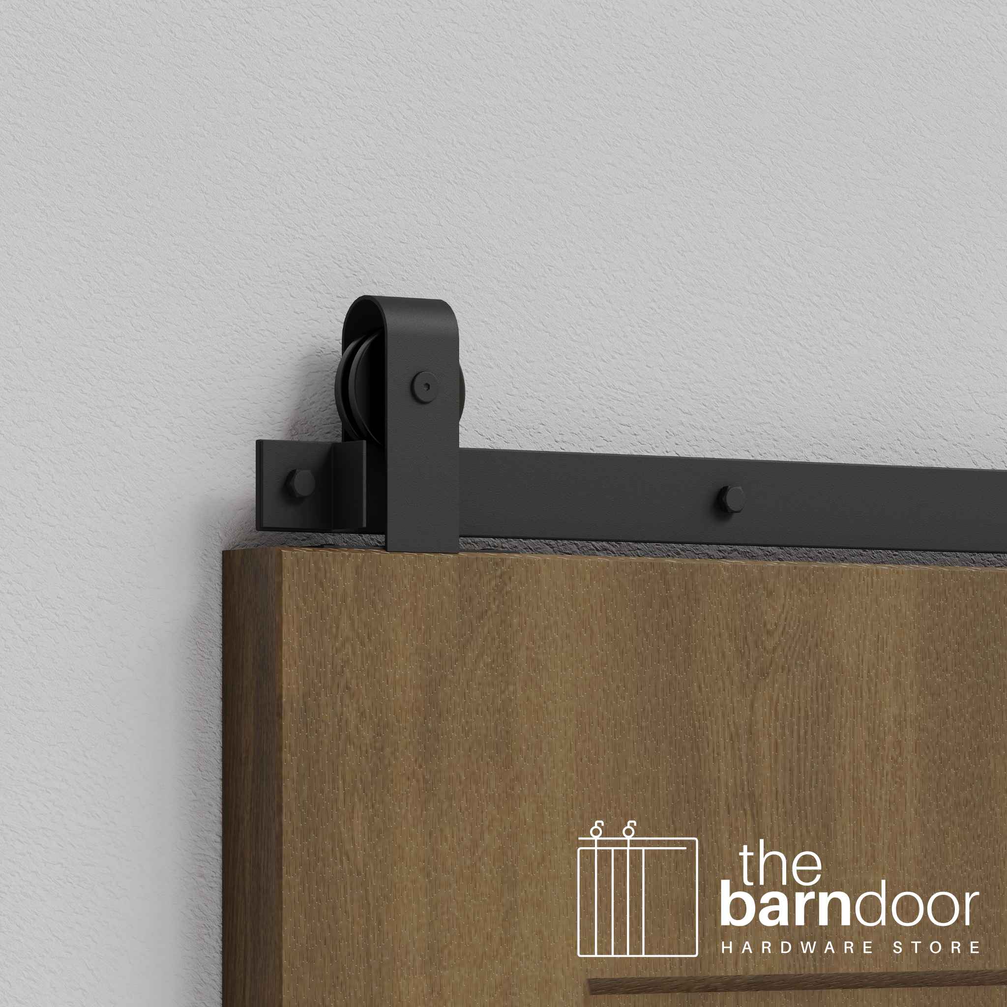 Close-up of Matte Black J Top Mount Single Track barn door hardware installed on a wooden door panel.