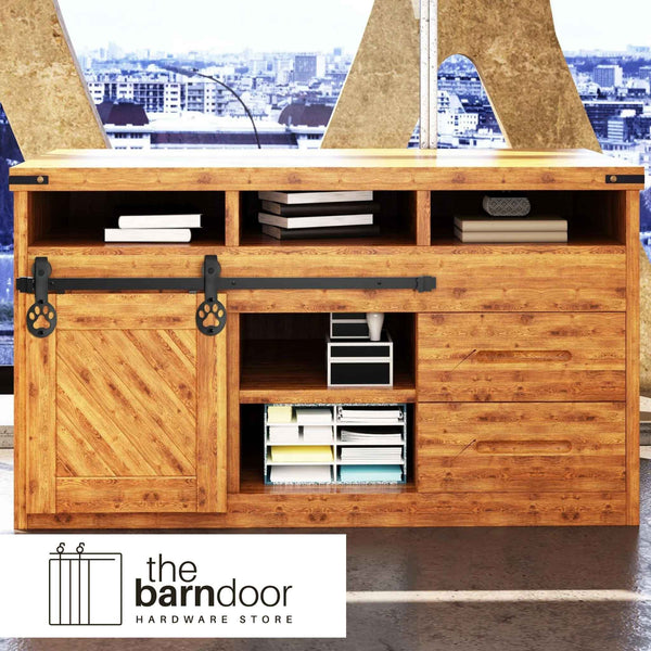 Puppy paw print cabinet barn door hardware kit in matte black with a single track, shown installed on a small wooden cabinet door.