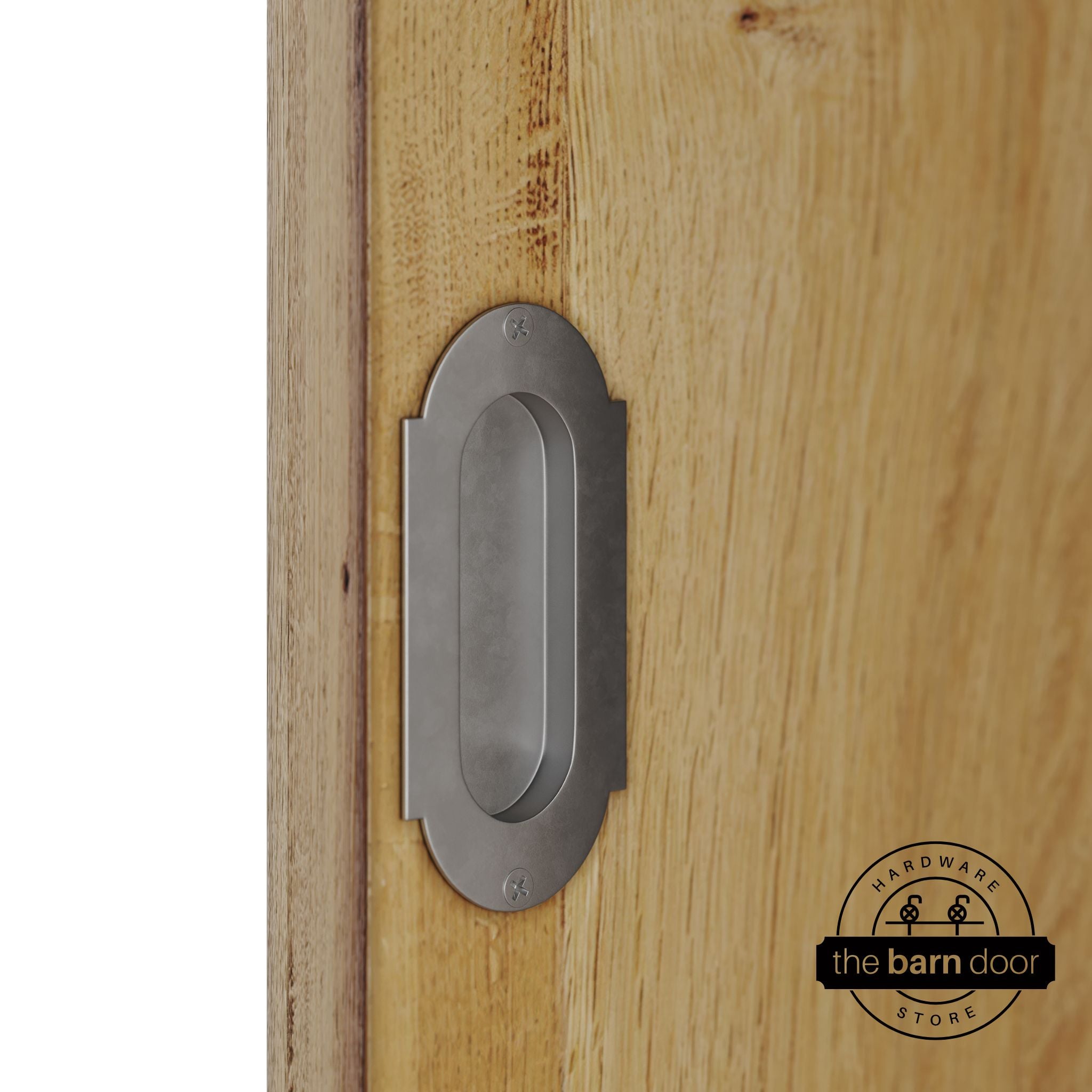 Raw steel flush pull handle with full radius wings mounted on a light oak barn door, brushed silver finish with oval recessed grip and four mounting screws